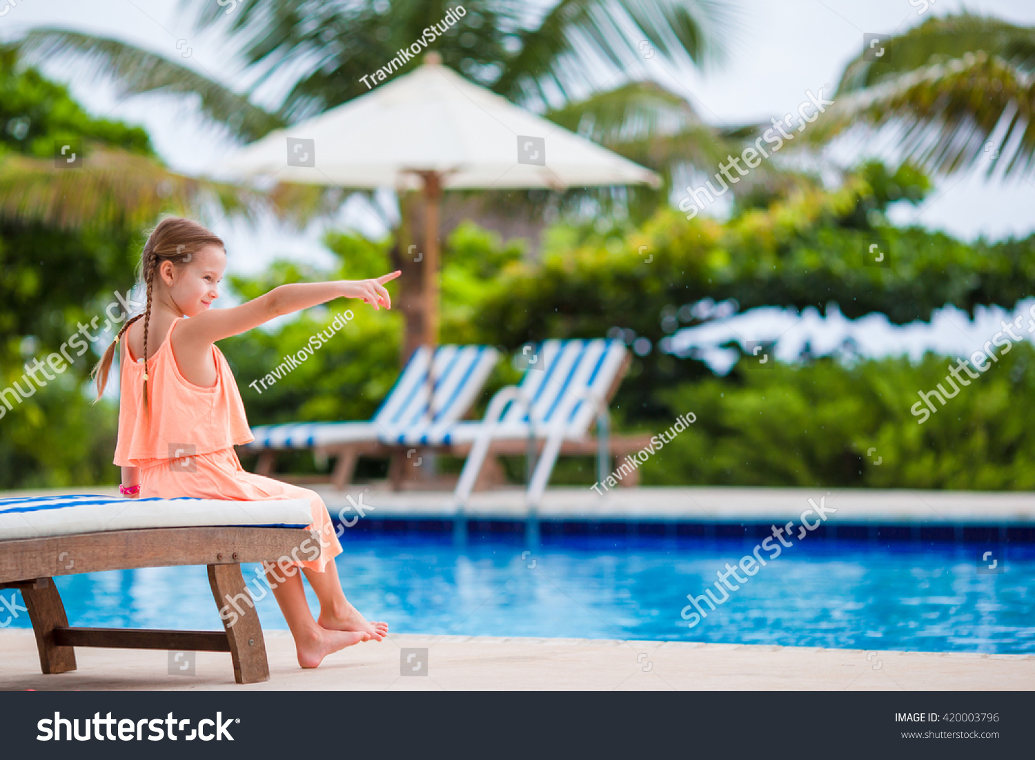 Adorable little girl making selfie near a swimming pool #420003796