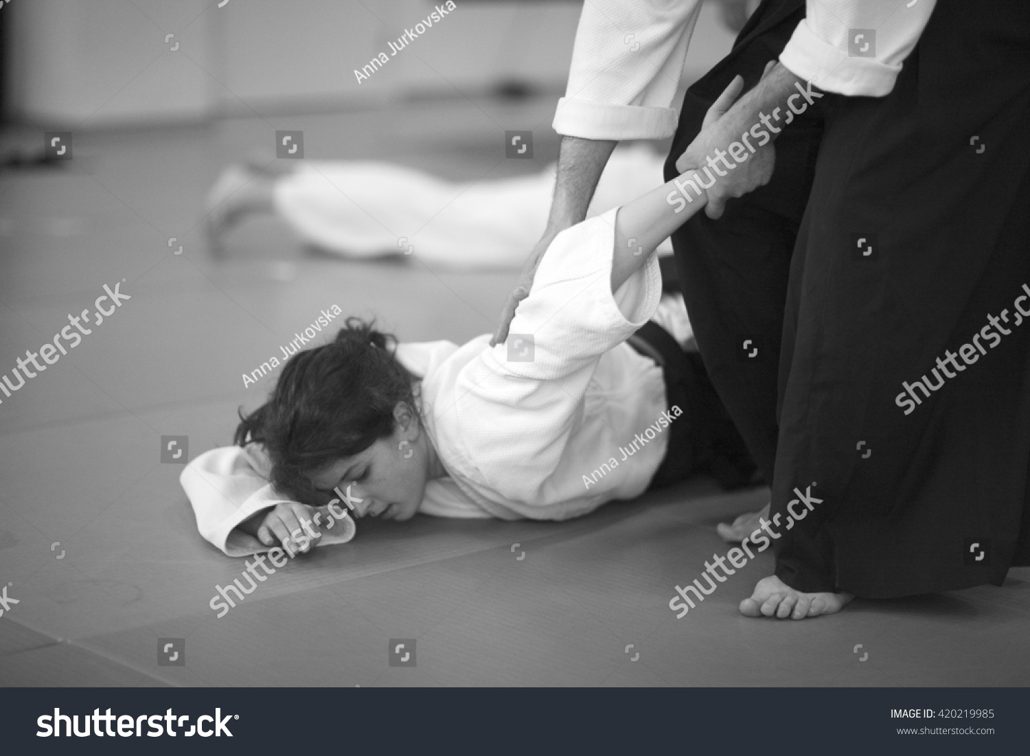 Woman in martial arts; young woman lying on the mat  #420219985