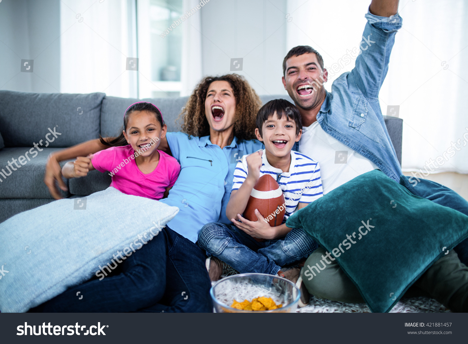 Family watching american football match on television at home #421881457