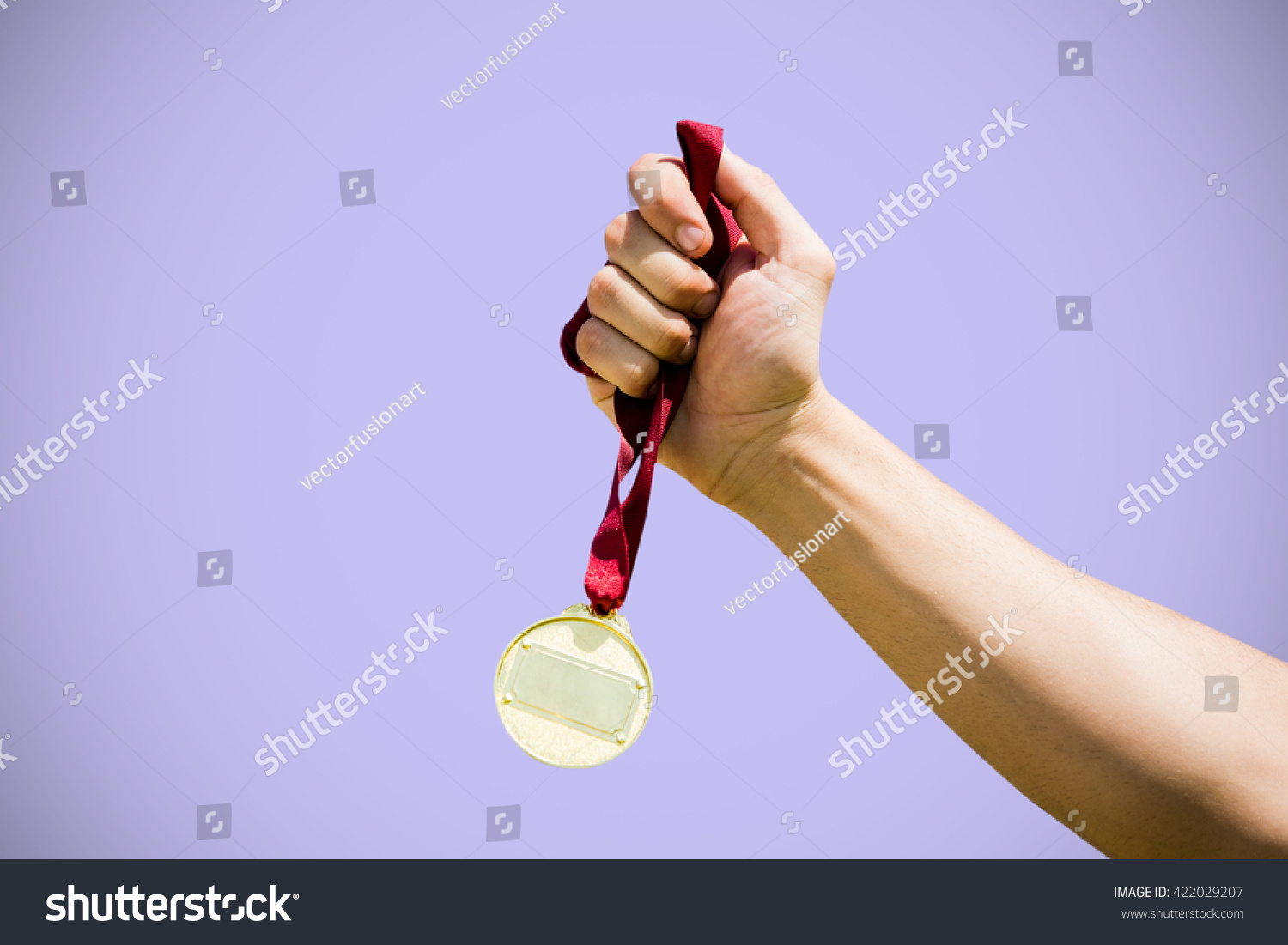 Hand holding a gold medal on white background against purple background #422029207