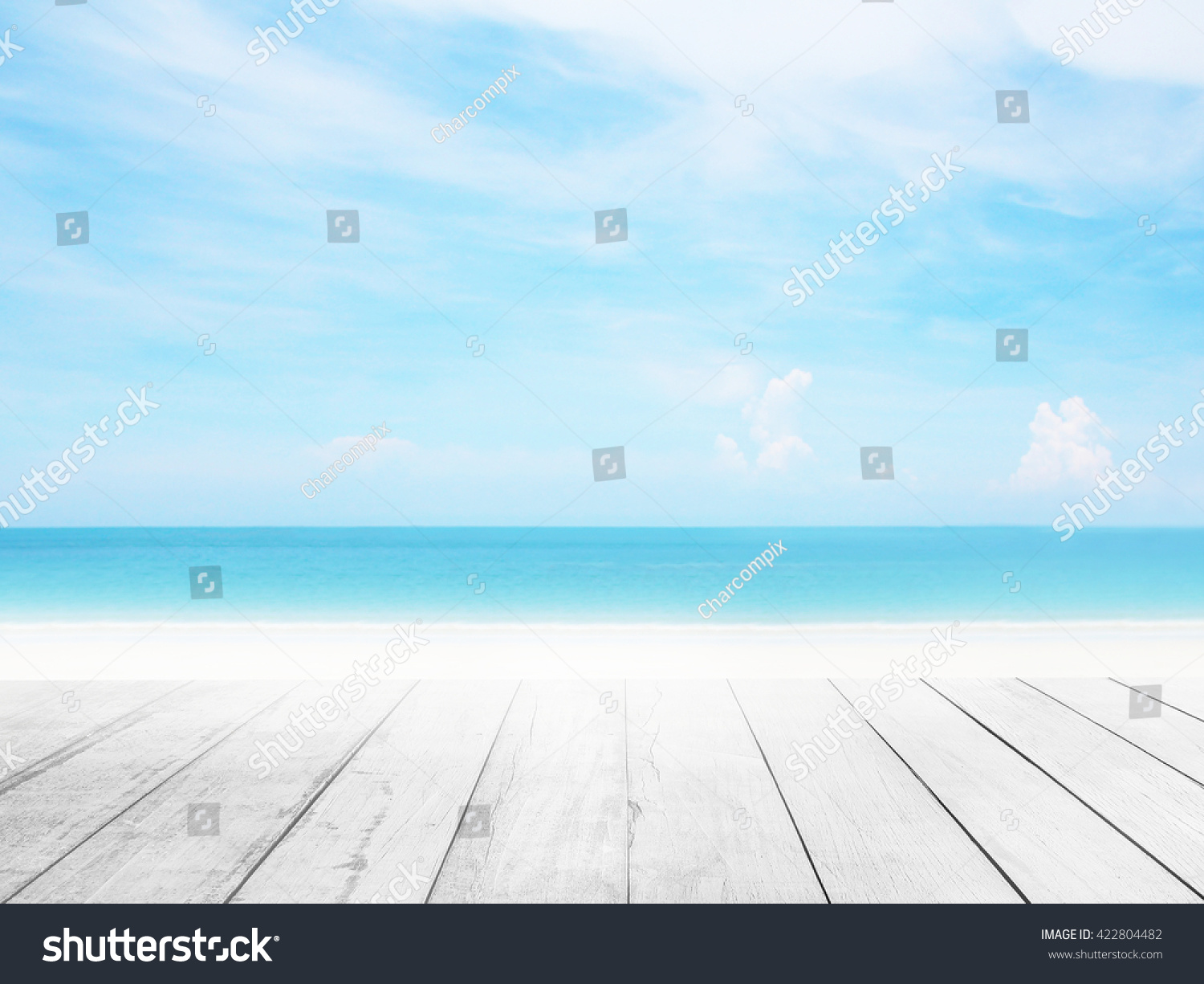 The blur cool sea background with wood floor foreground on horizon tropical sandy beach; relaxing outdoors vacation with heavenly mind view at a resort deck touching sunshine, sky surf summer clouds. #422804482