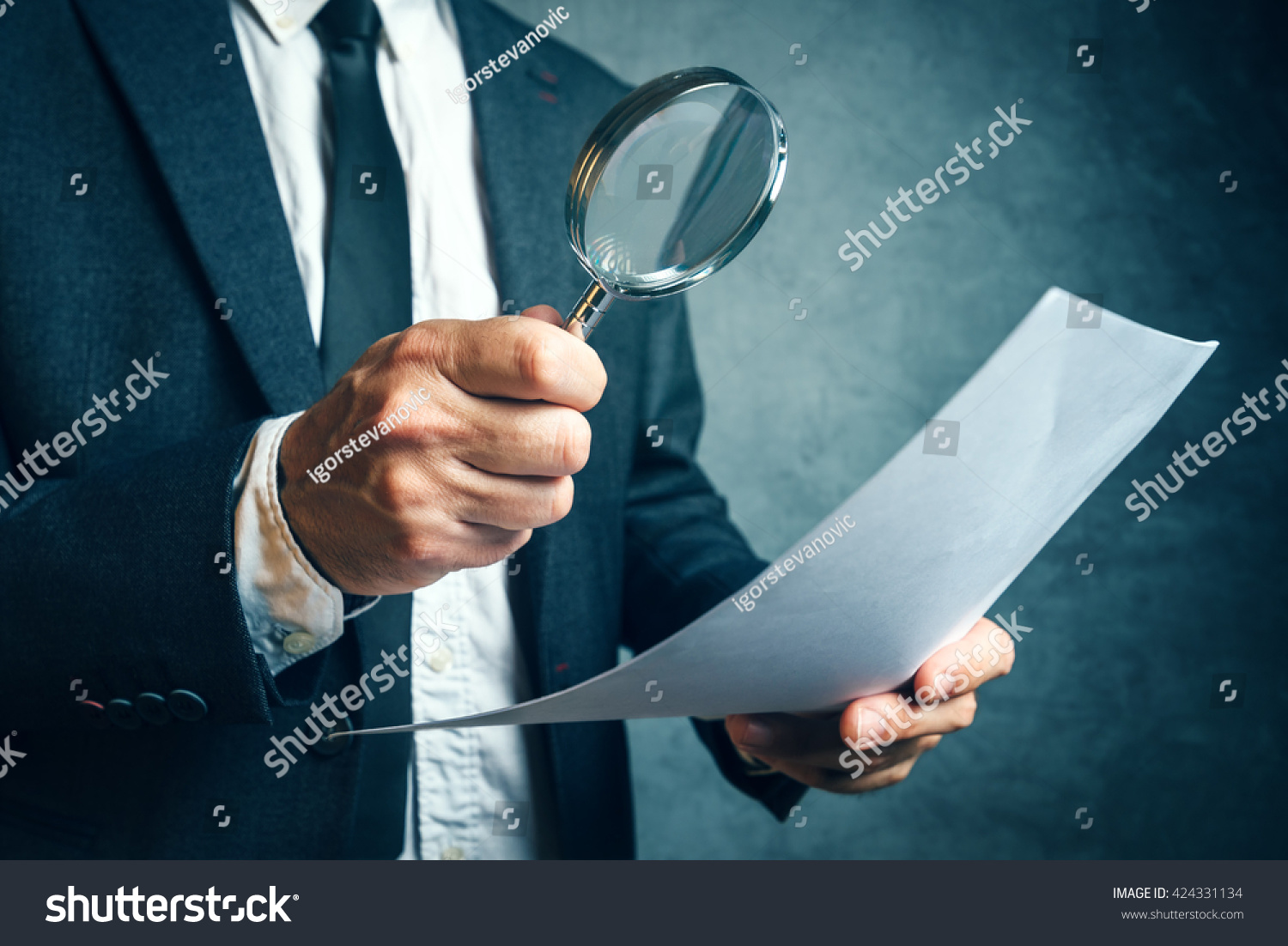 Tax inspector investigating offshore company documents and papers with magnifying glass, forensic accounting concept #424331134