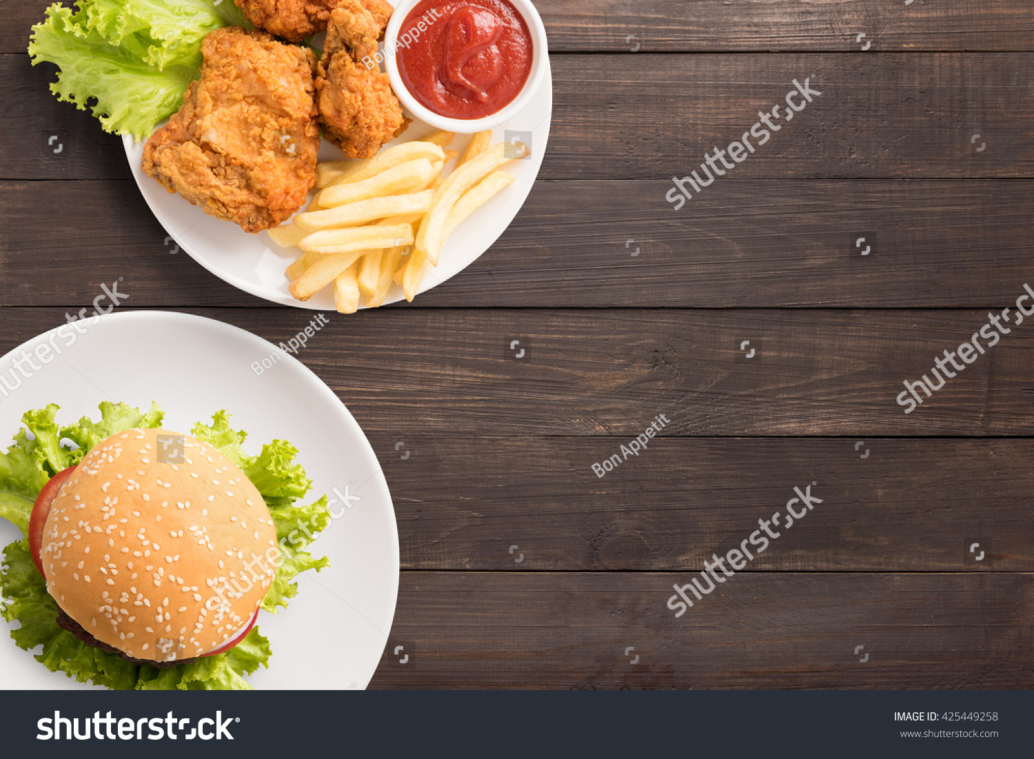Fast food big hamburger on wooden background. Fast food set fried chicken and french fries. Take away fast food.  #425449258