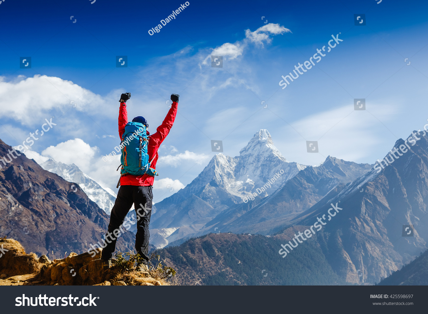Hiker cheering elated and blissful with arms raised in the sky after hiking. Everest base camp trek #425598697