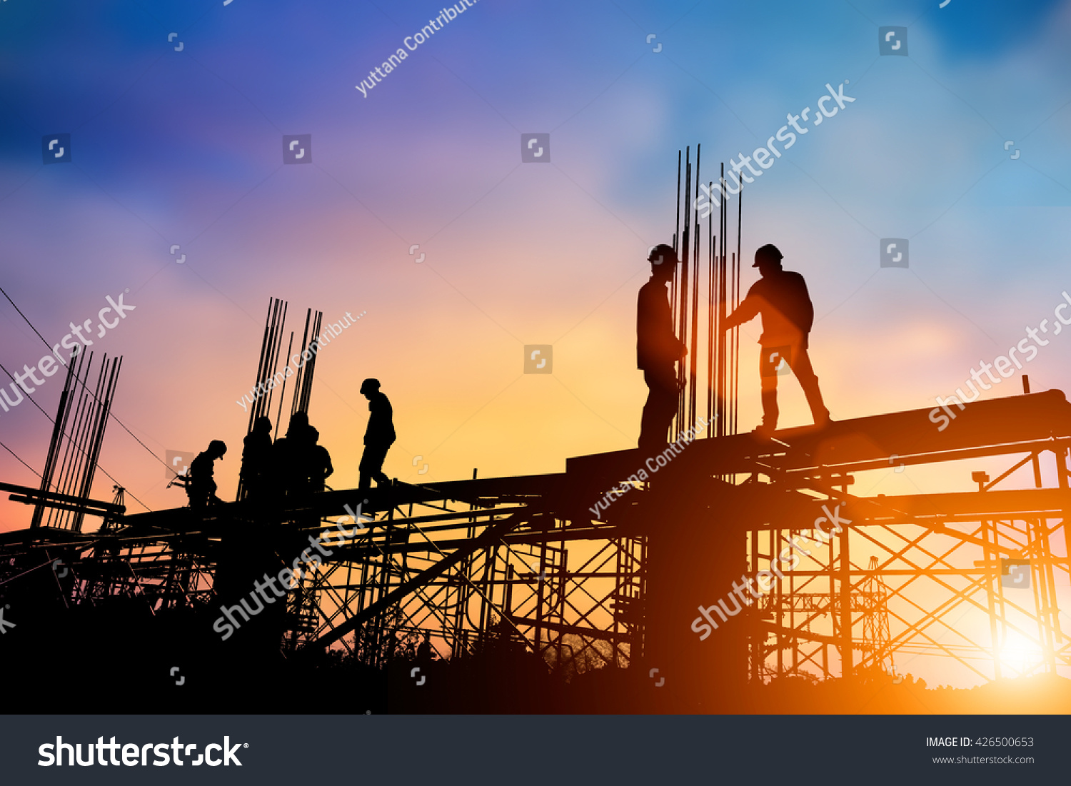 Silhouette engineer standing orders for construction crews to work on high ground  heavy industry and safety concept over blurred natural background sunset pastel #426500653