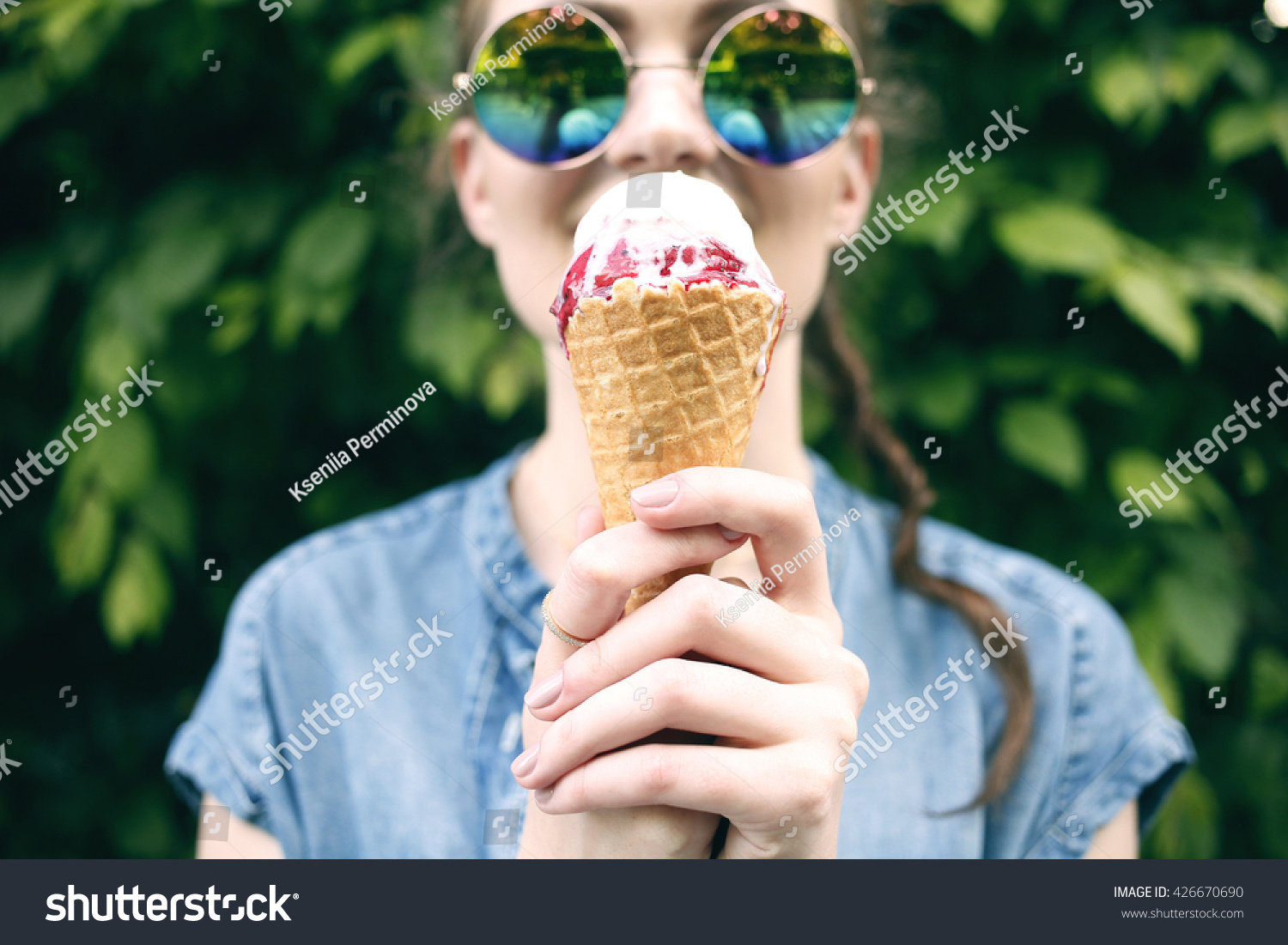 Outdoor closeup fashion portrait of young hipster crazy girl eating ice cream in summer hot weather in round mirror sunglasses have fun and good mood. Toned style instagram filters #426670690
