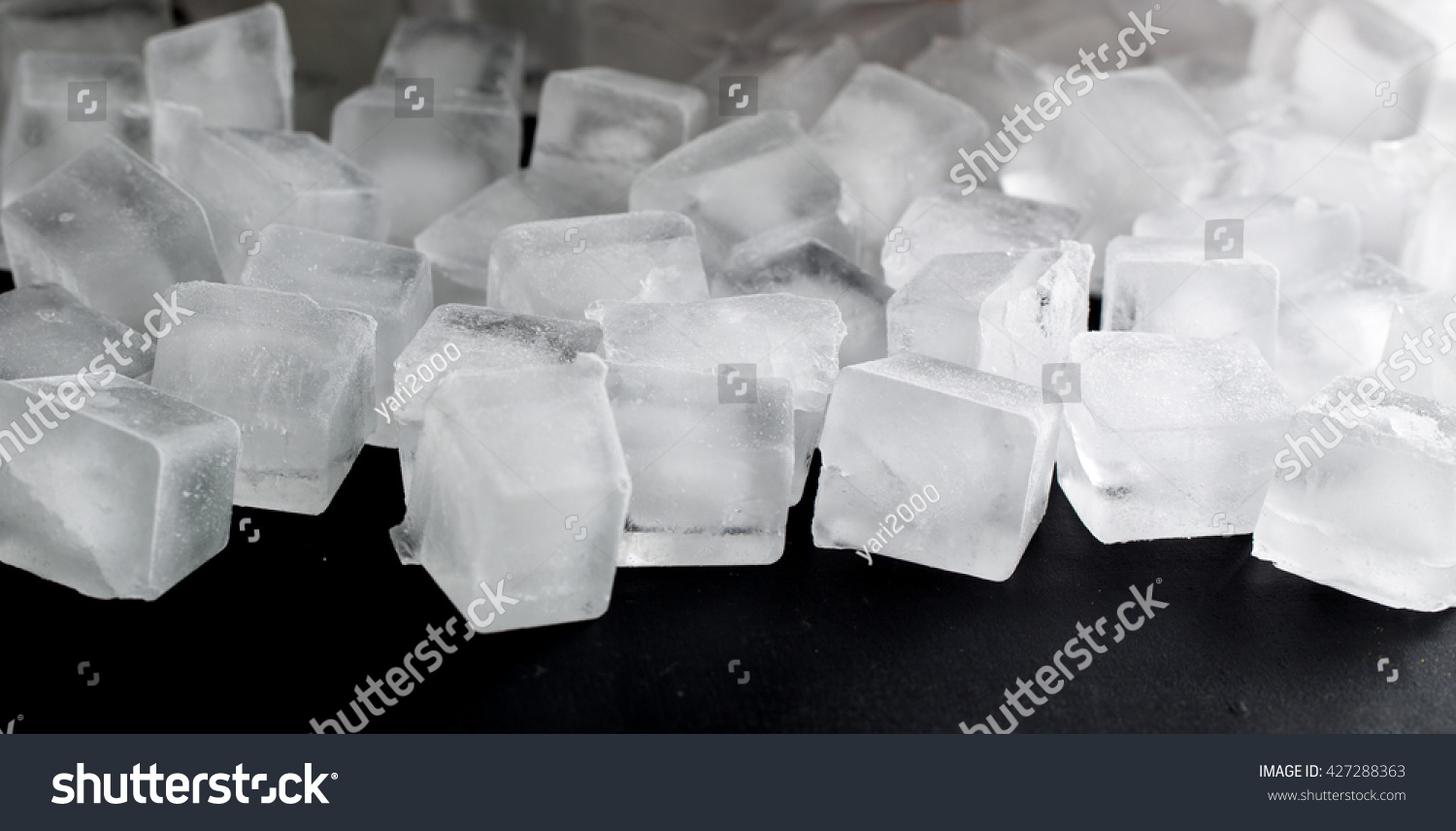 pile of different ice cubes on black background #427288363