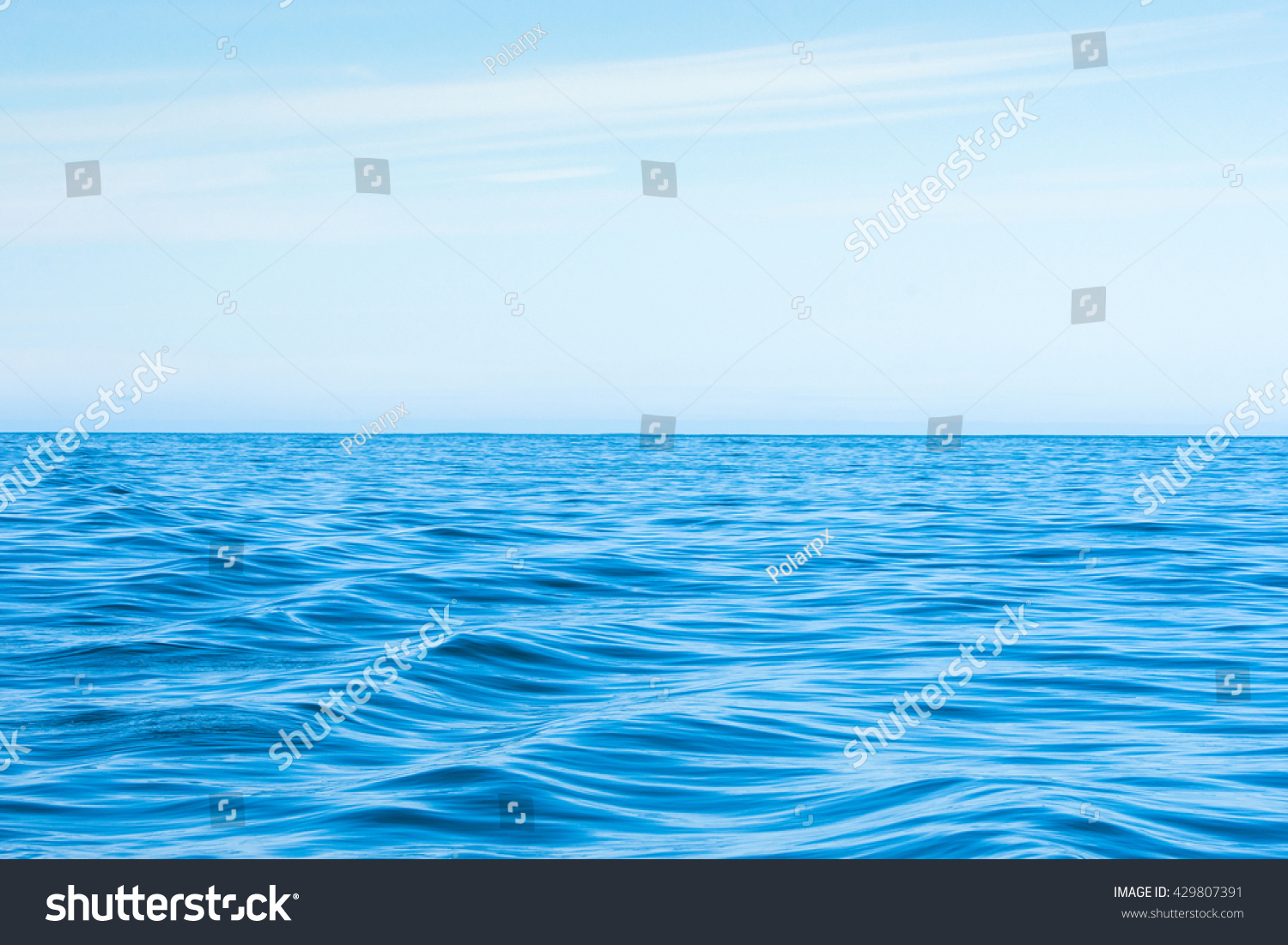 Wavy blue ocean with clouds in the blue sky #429807391