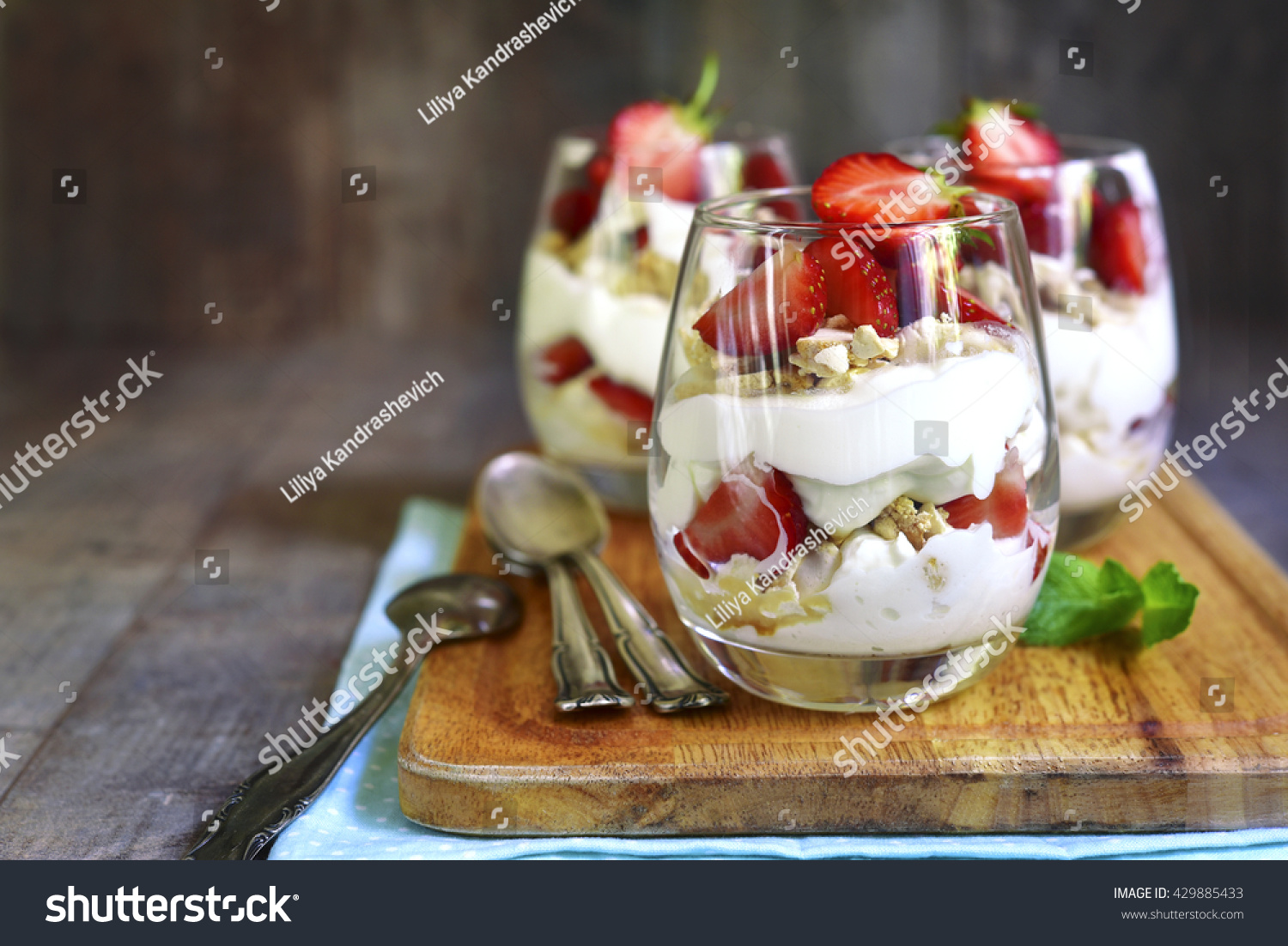 Delicious traditional english dessert eton mess with strawberry on a wooden background. #429885433