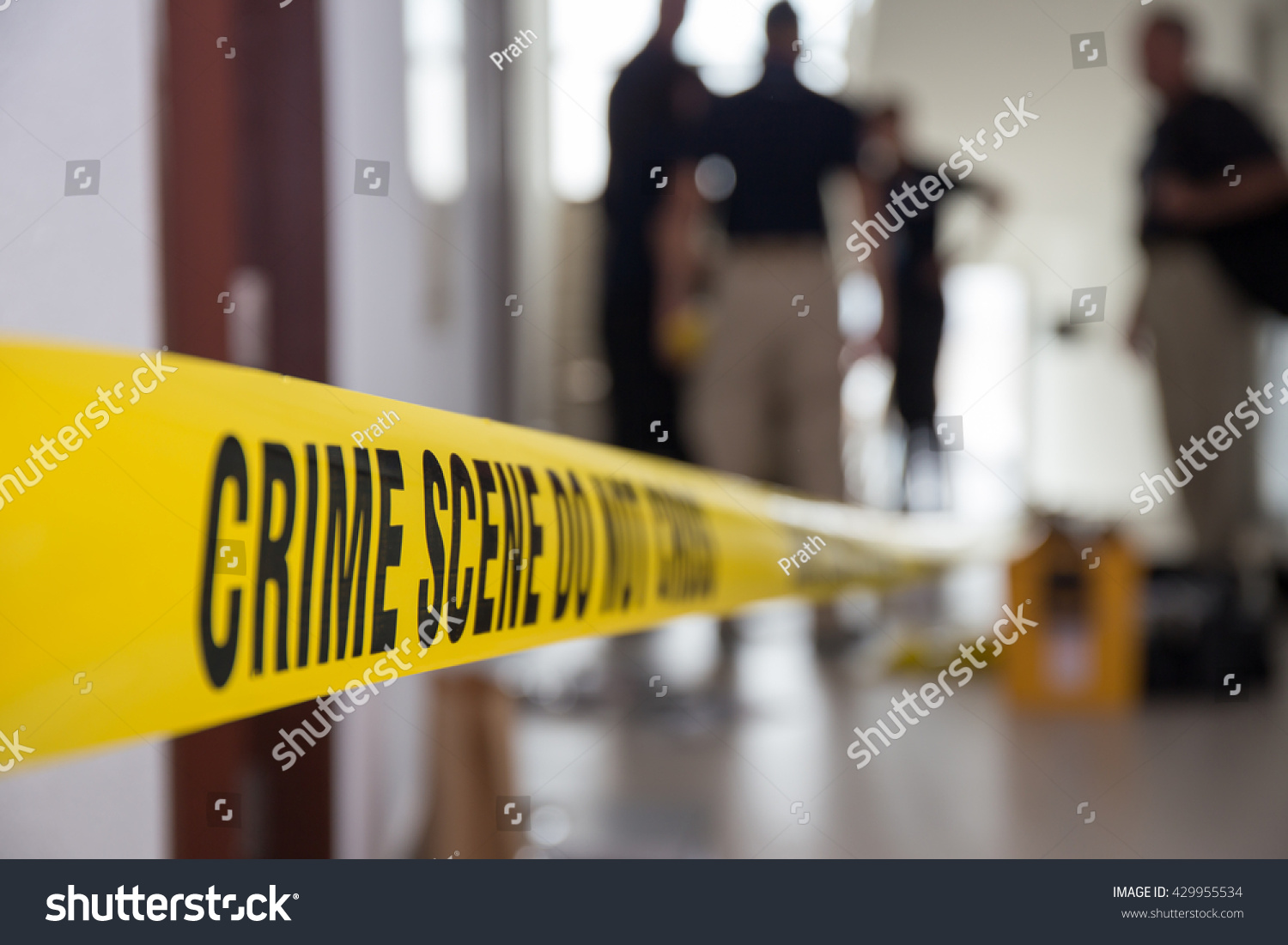 crime scene tape in building with blurred forensic team background #429955534