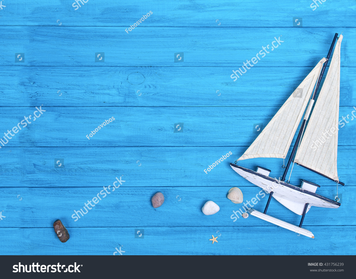 Sea elements with souvenir sailboat on blue wooden desk #431756239