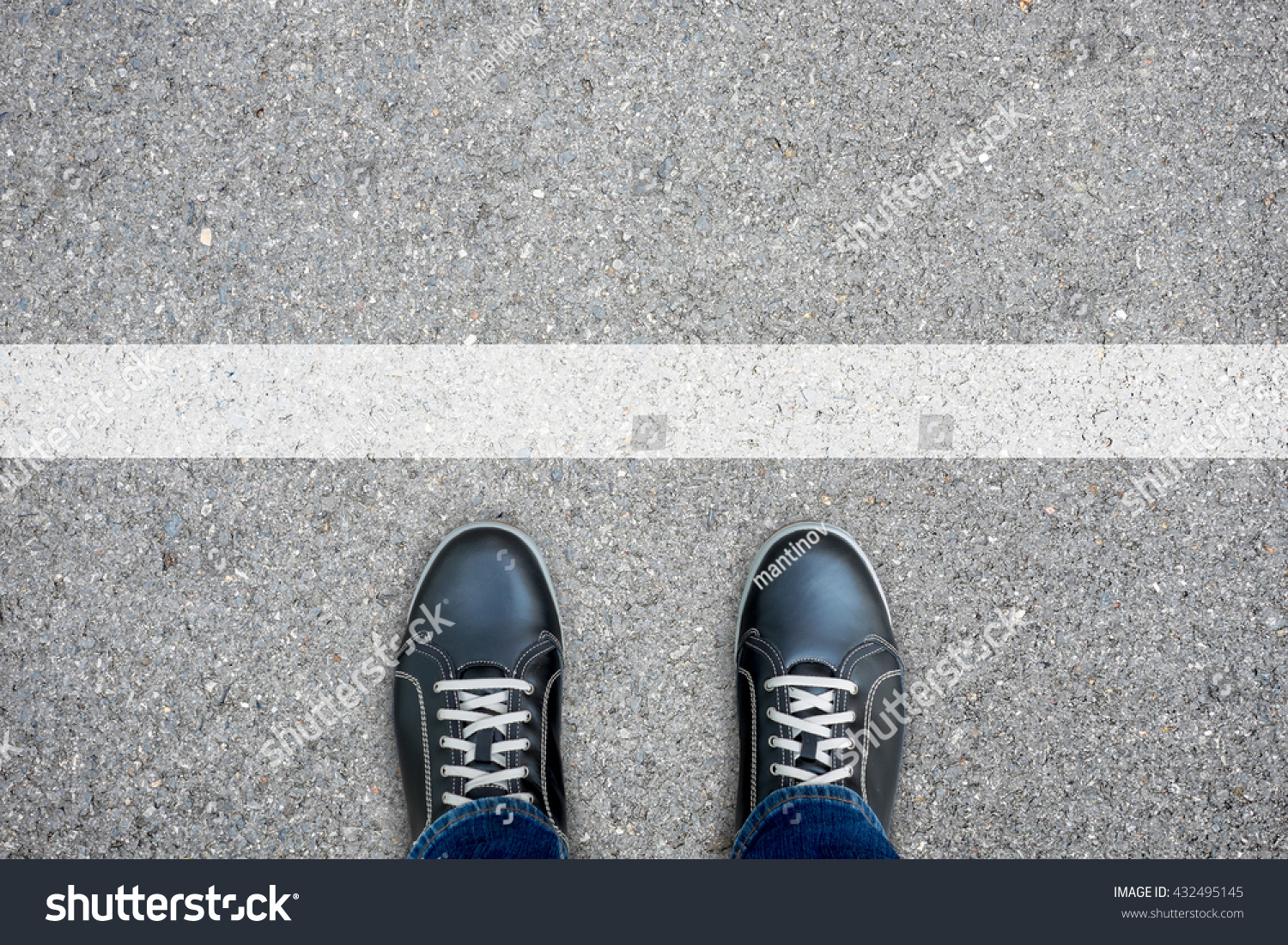 Black casual shoes standing at the white line making decision - stop and turn back or across the line and go further #432495145