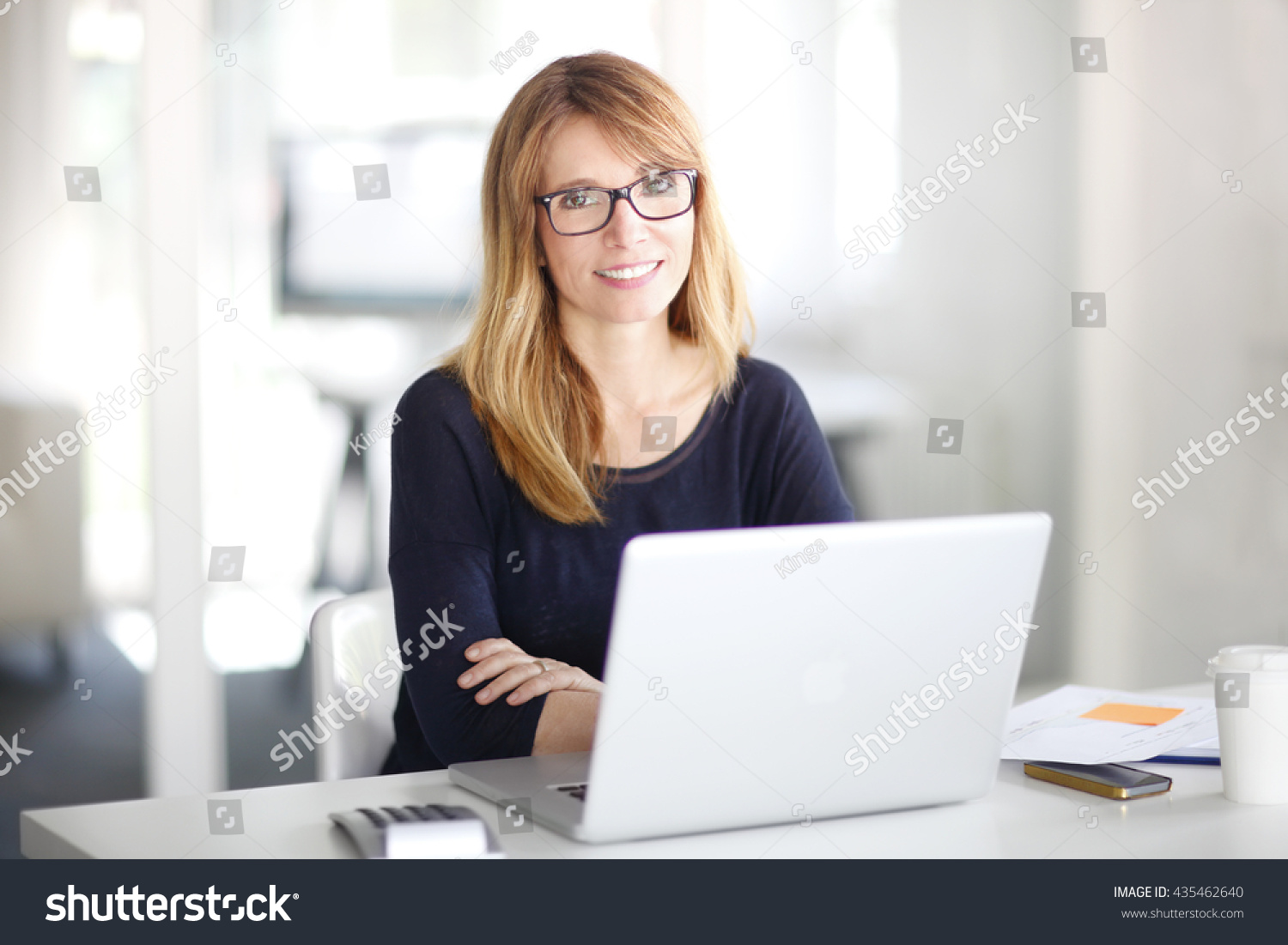 Portrait of an executive investment advisor professional woman sitting at office and working on laptop. #435462640