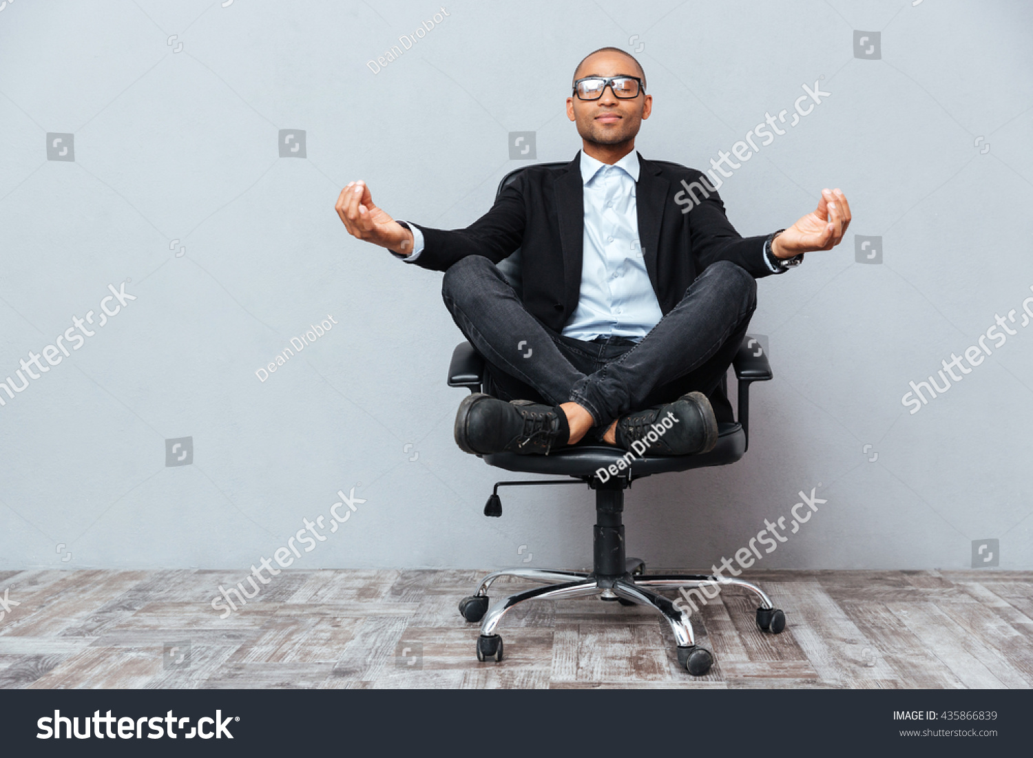 Relaxed handsome african young man sitting and meditating on office chair #435866839