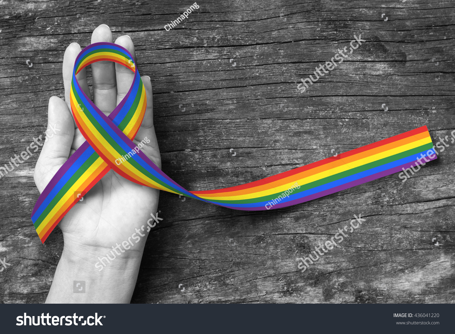 Rainbow color ribbon awareness on human hand with clipping path for Adrenocortical carcinoma and gay pride awareness ribbon #436041220