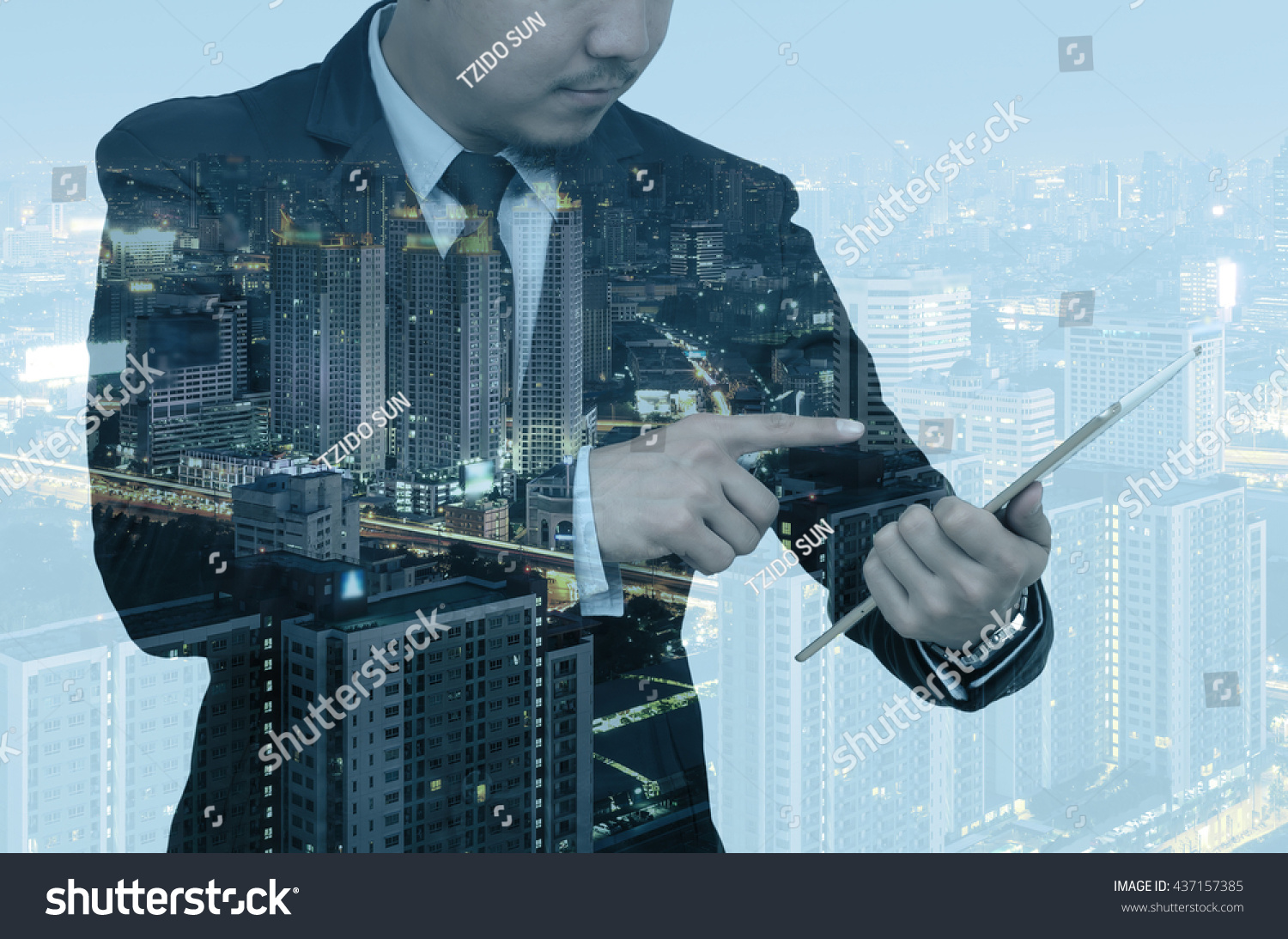 Double exposure of businessman using the tablet on cityscape background, Business real estate concept #437157385