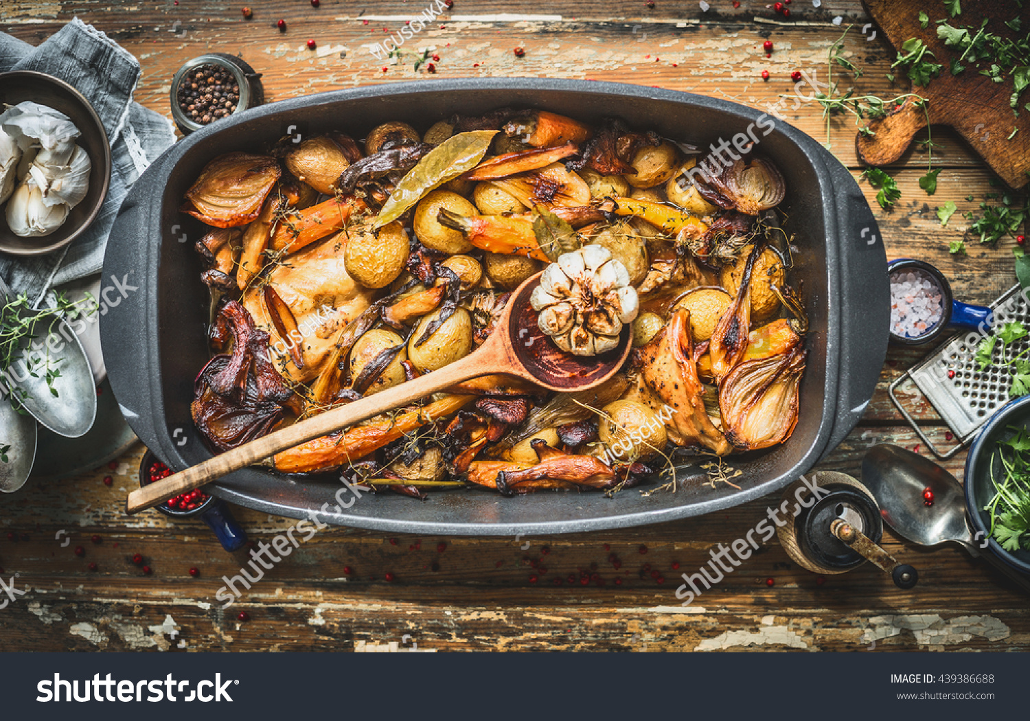  Stew with roasted vegetables, forest mushrooms and wild hunting fowl in cooking pot with wooden spoon. Rabbit ragout on rustic aged background with spoons,plates and fresh seasoning, top view #439386688