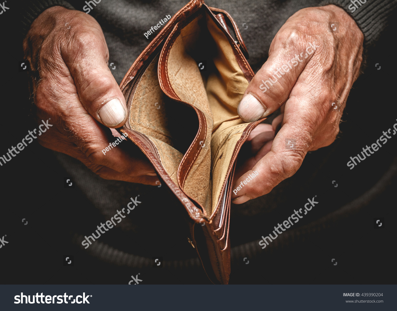 Empty wallet in the hands of an elderly man. Poverty in retirement concept #439390204