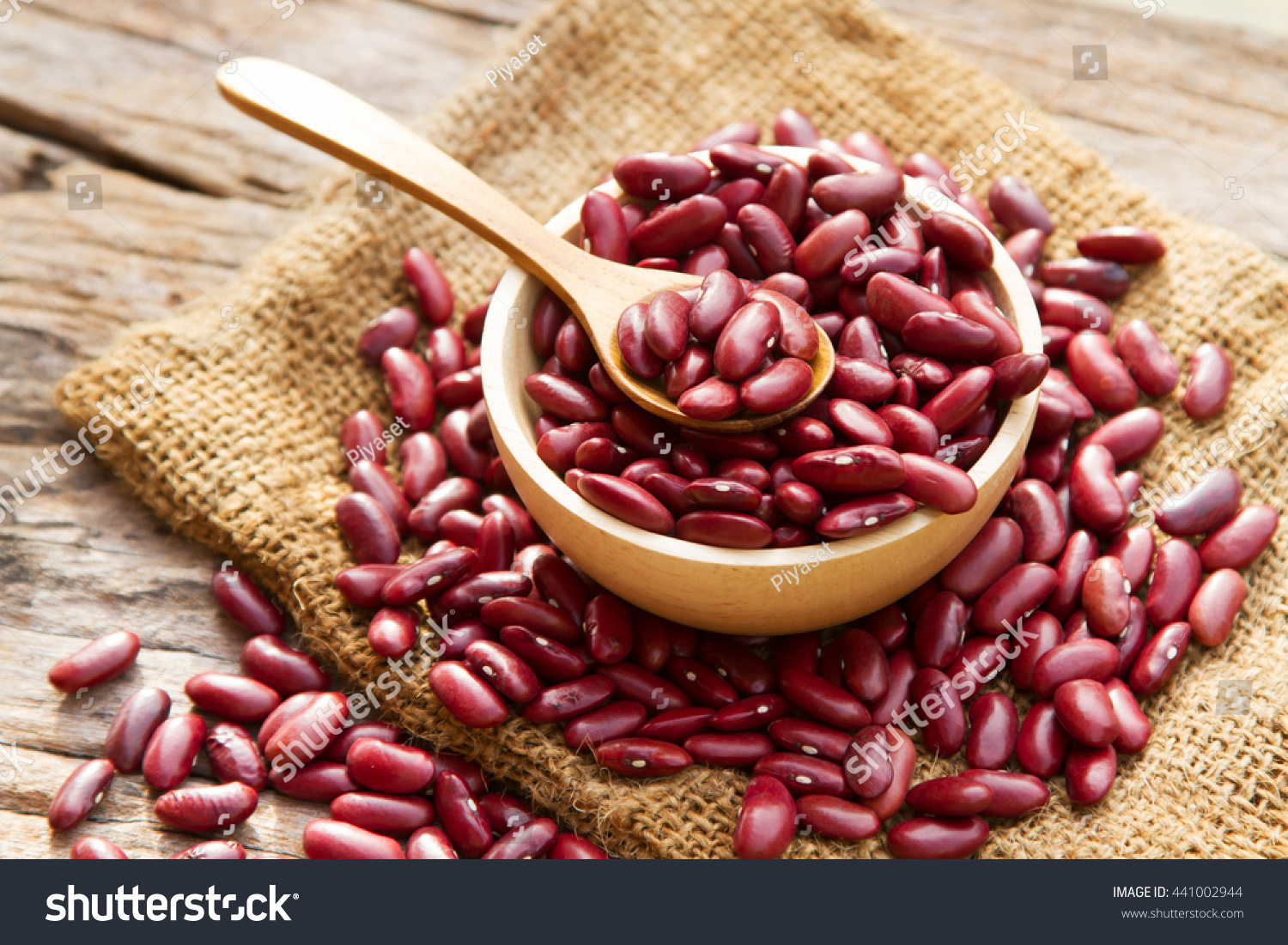 Grains Red bean in wooden bowl and spoon putting on linen and wood background #441002944