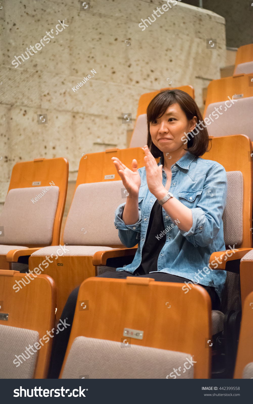 One woman sitting in a chair in the concert hall #442399558