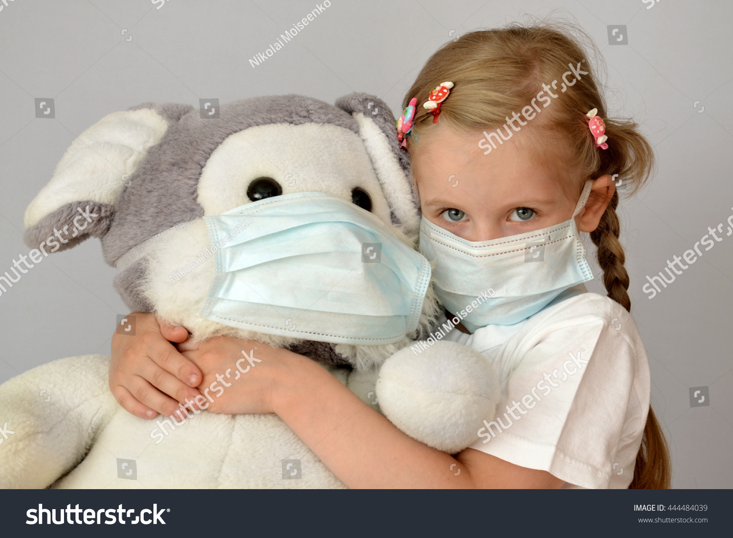 portrait of a sick child in a medical mask with a soft toy #444484039