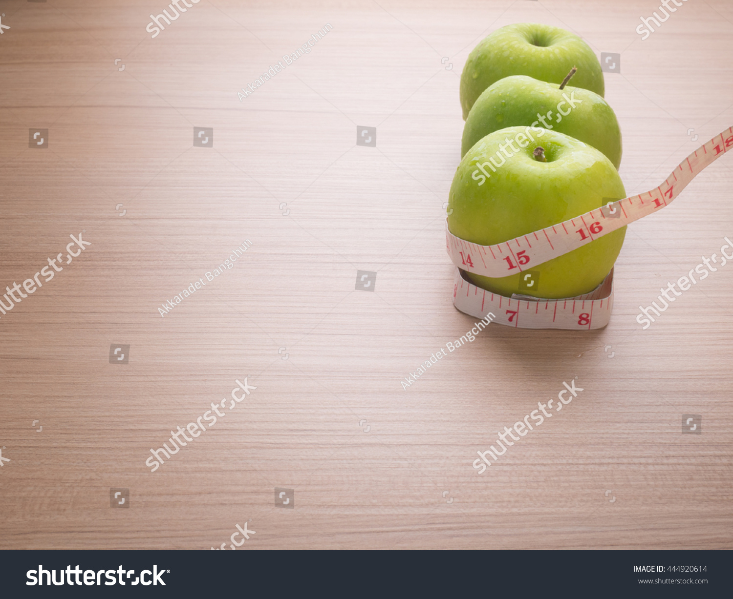 Apples with tape measure on brown wood background, lose weight concept #444920614