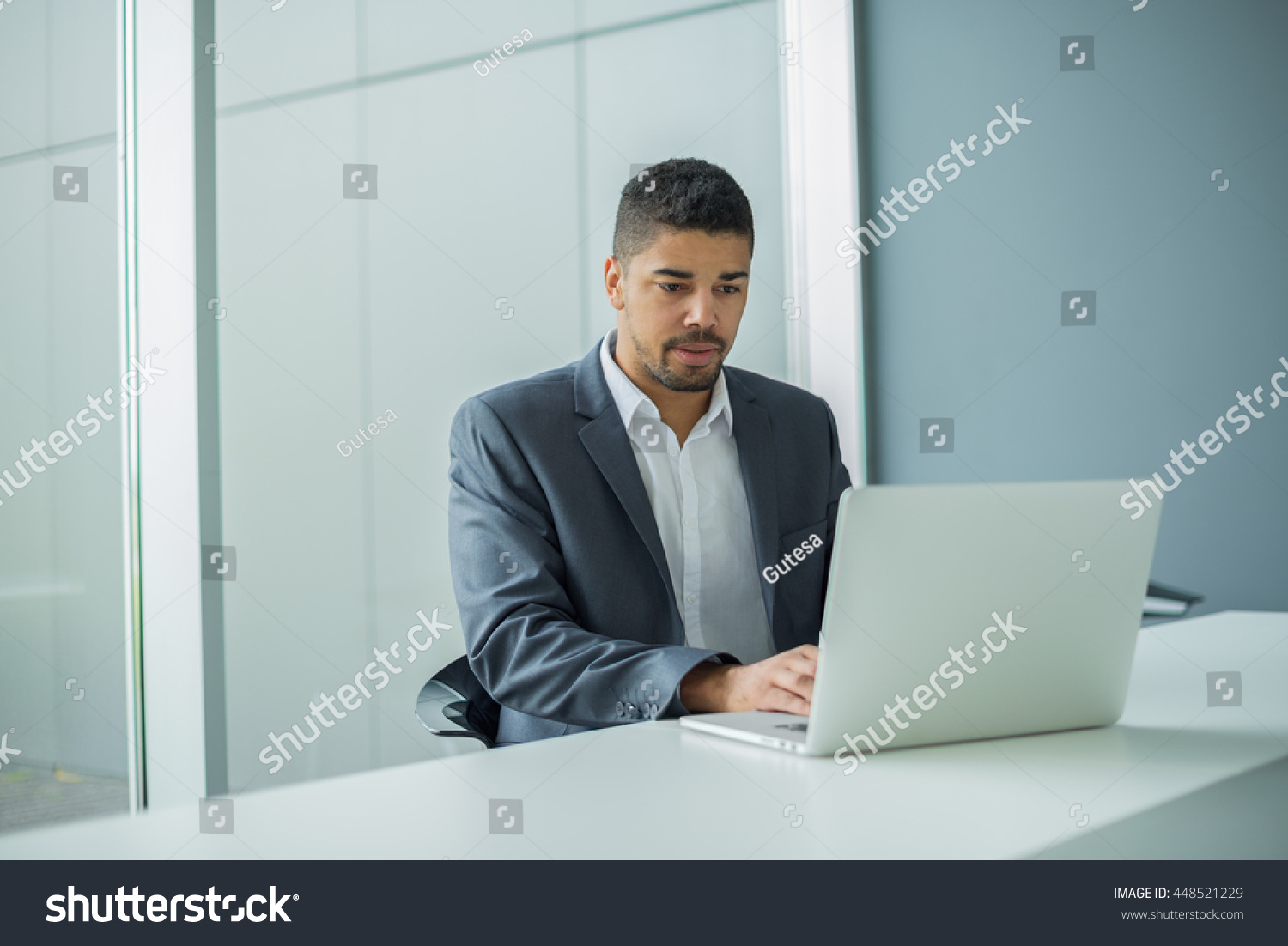 Young businessman lawyer with laptop, alone in big bright conference room. #448521229