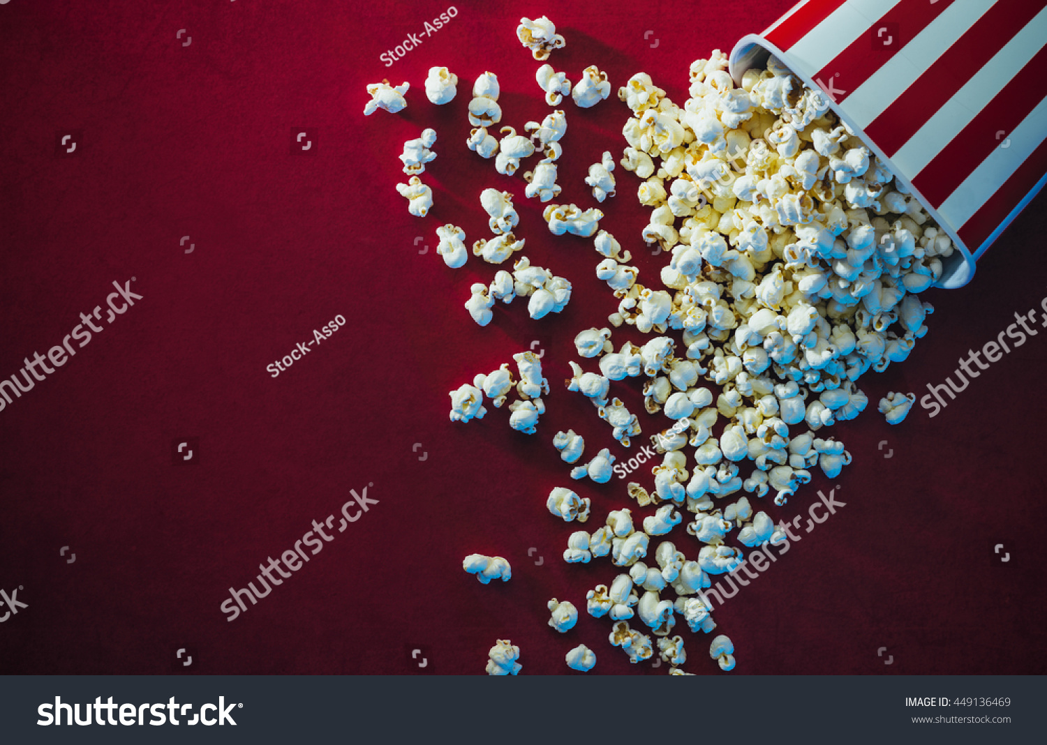 Spilled popcorn on a red background, cinema, movies and entertainment concept #449136469