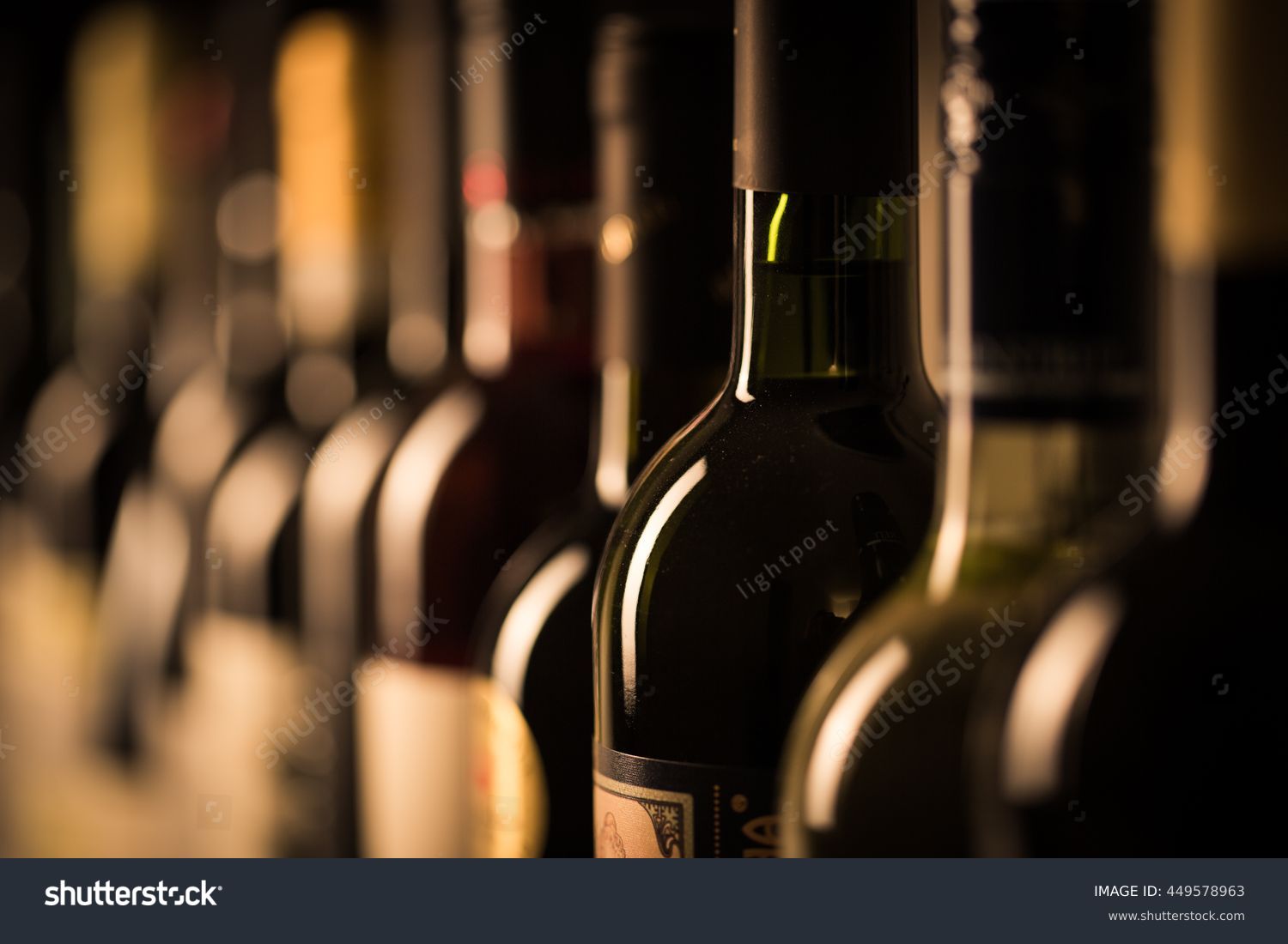 Row of vintage wine bottles in a wine cellar (shallow DOF; color toned image) #449578963