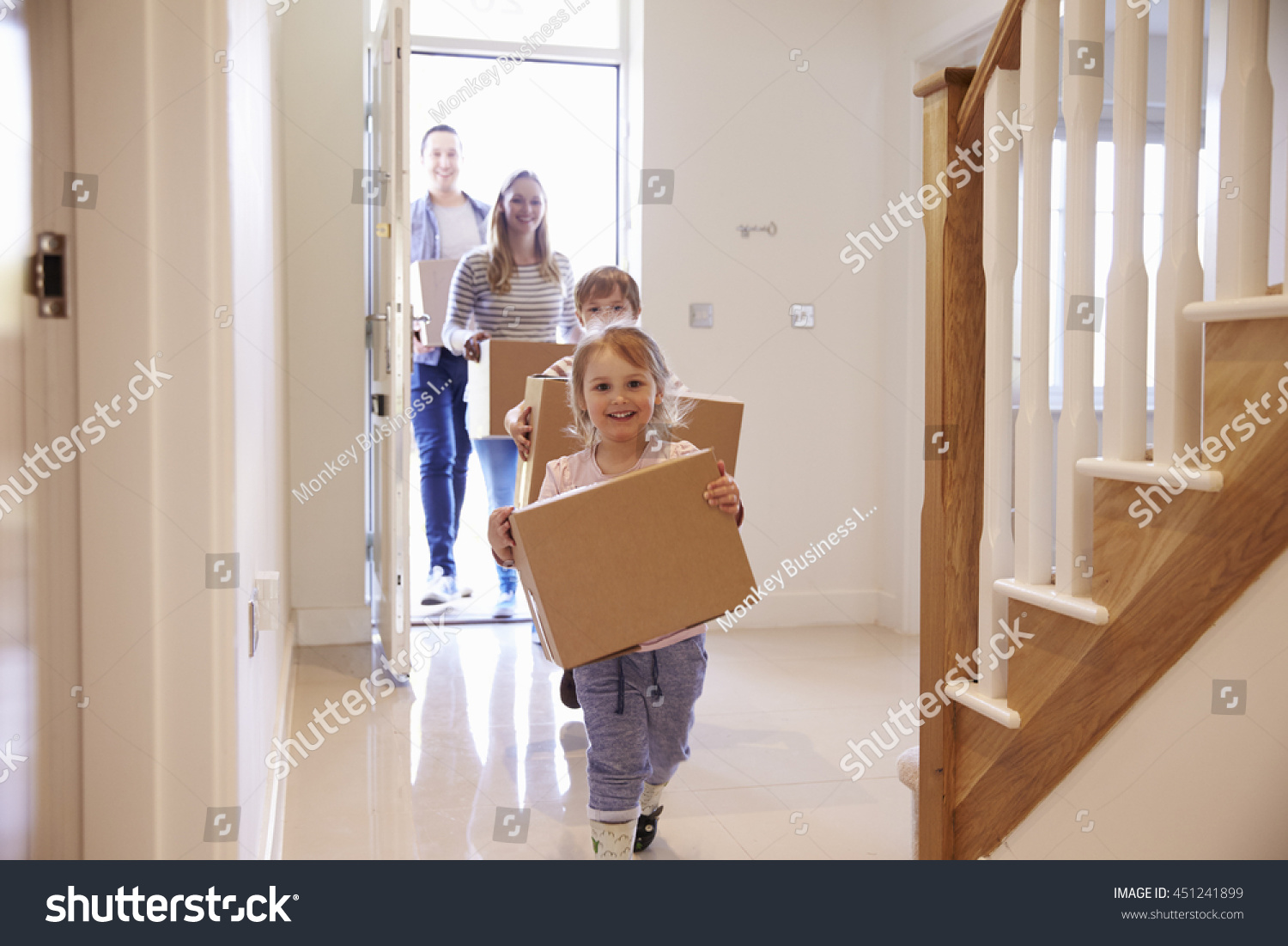 Family Carrying Boxes Into New Home On Moving Day #451241899