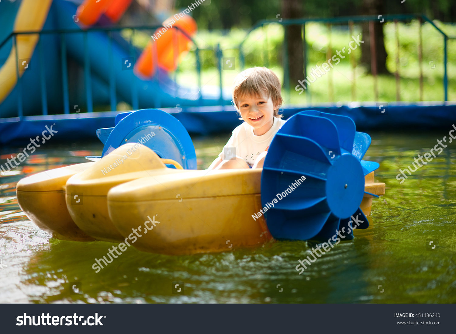 small child rides on a small catamaran in the pool #451486240