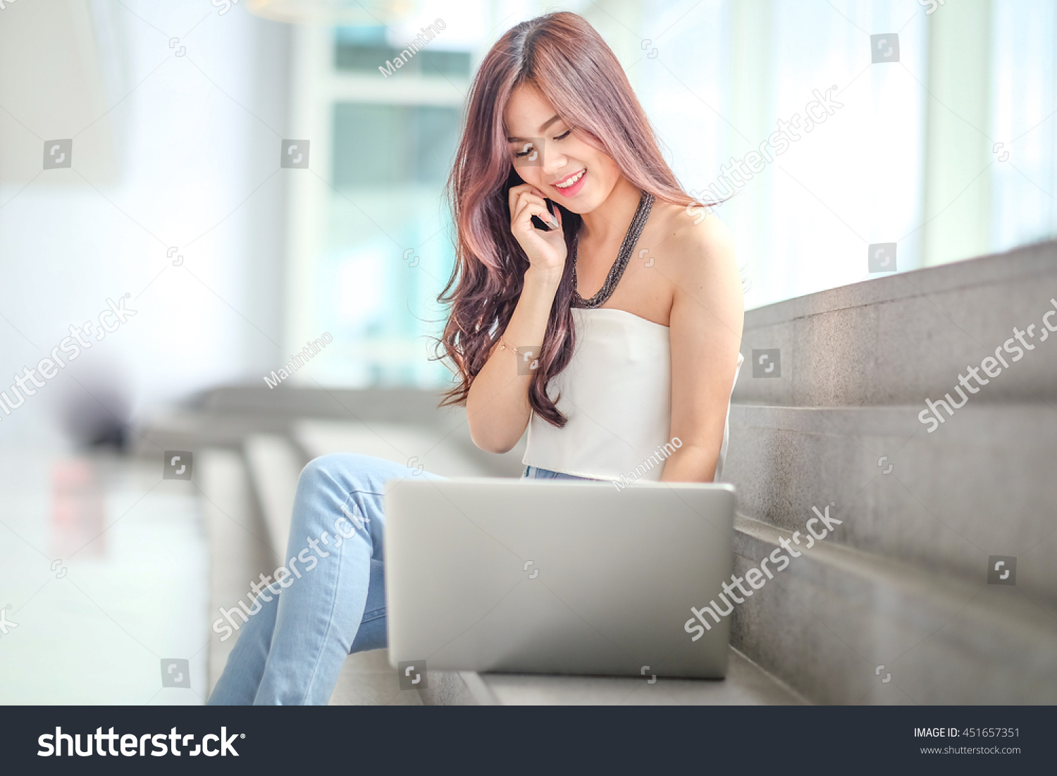 Portrait of a casual young businesswoman using laptop computer in office #451657351