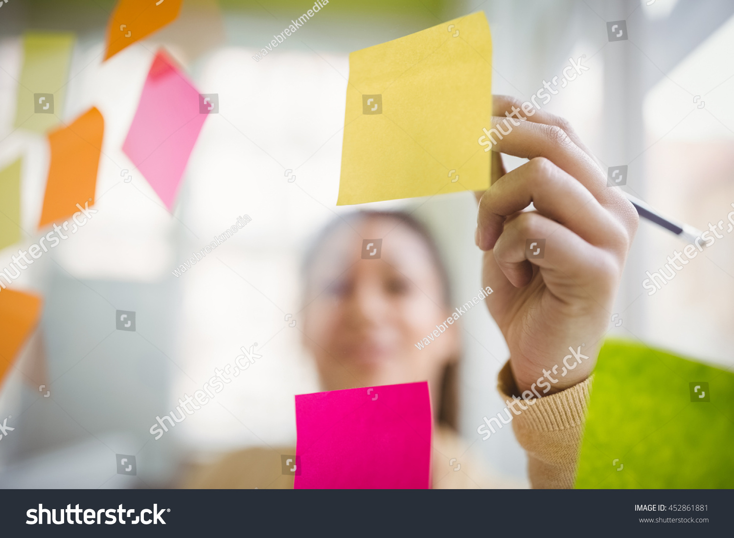 Businesswoman writing on adhesive notes in creative office #452861881
