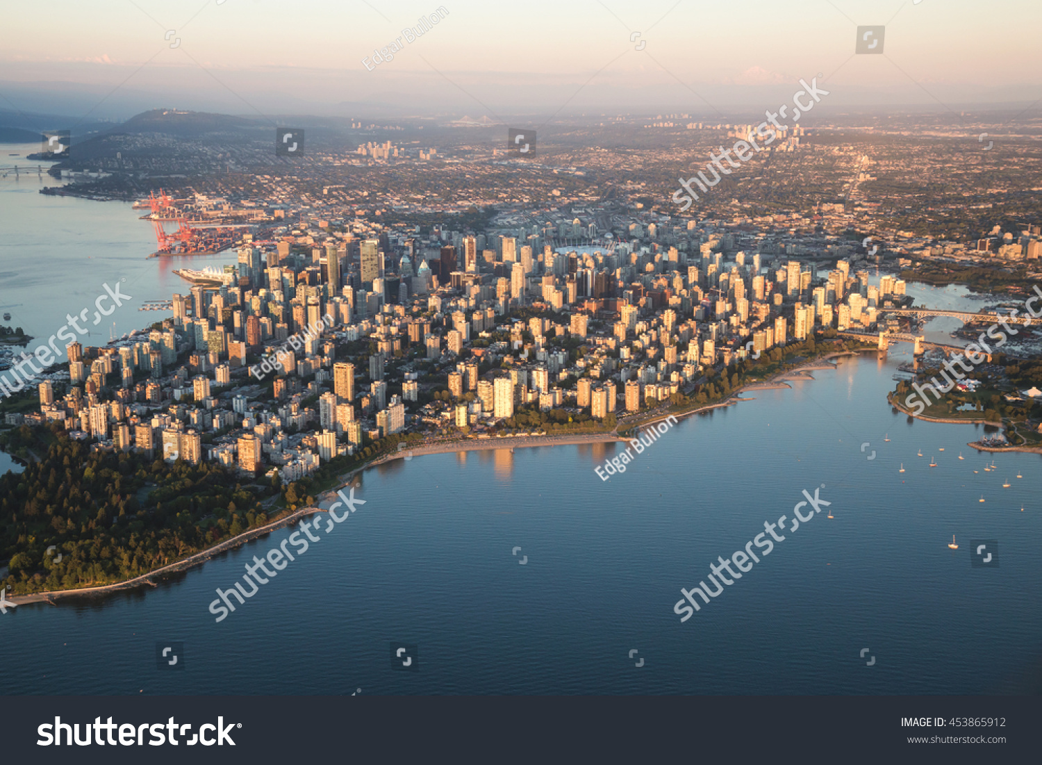Aerial view of Stanley Park and Downtown Vancouver, BC, Canada. During a hazy sunny sunset. #453865912