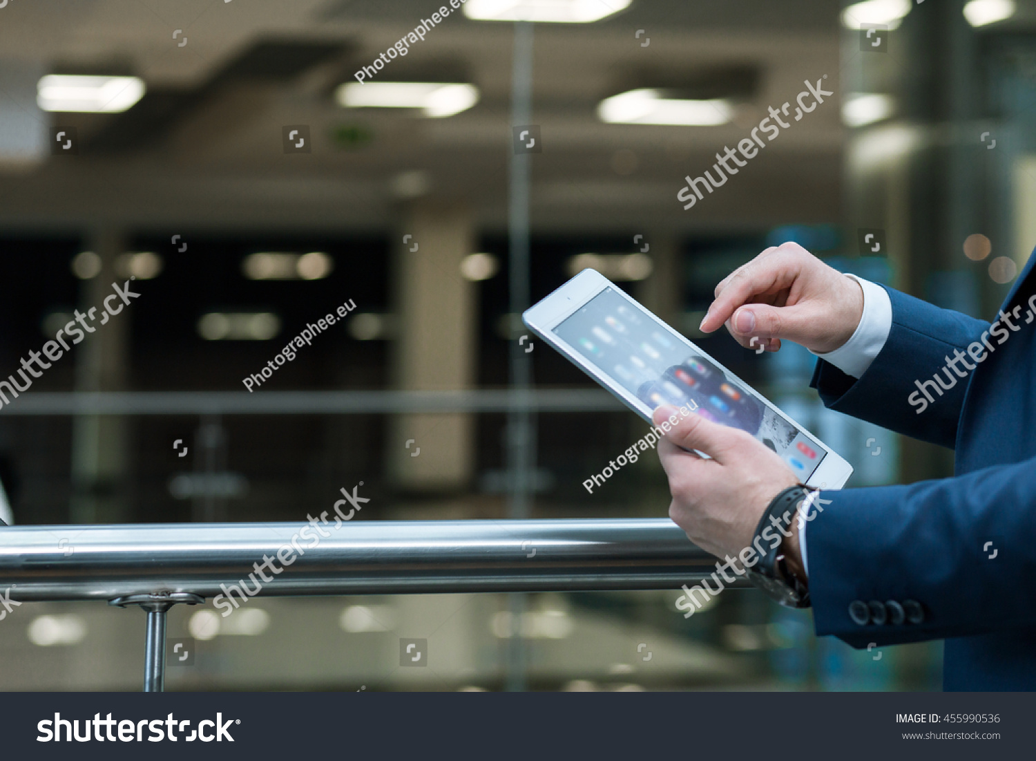 Close shot of an elegant man's hands holding a tablet, close to the railing #455990536