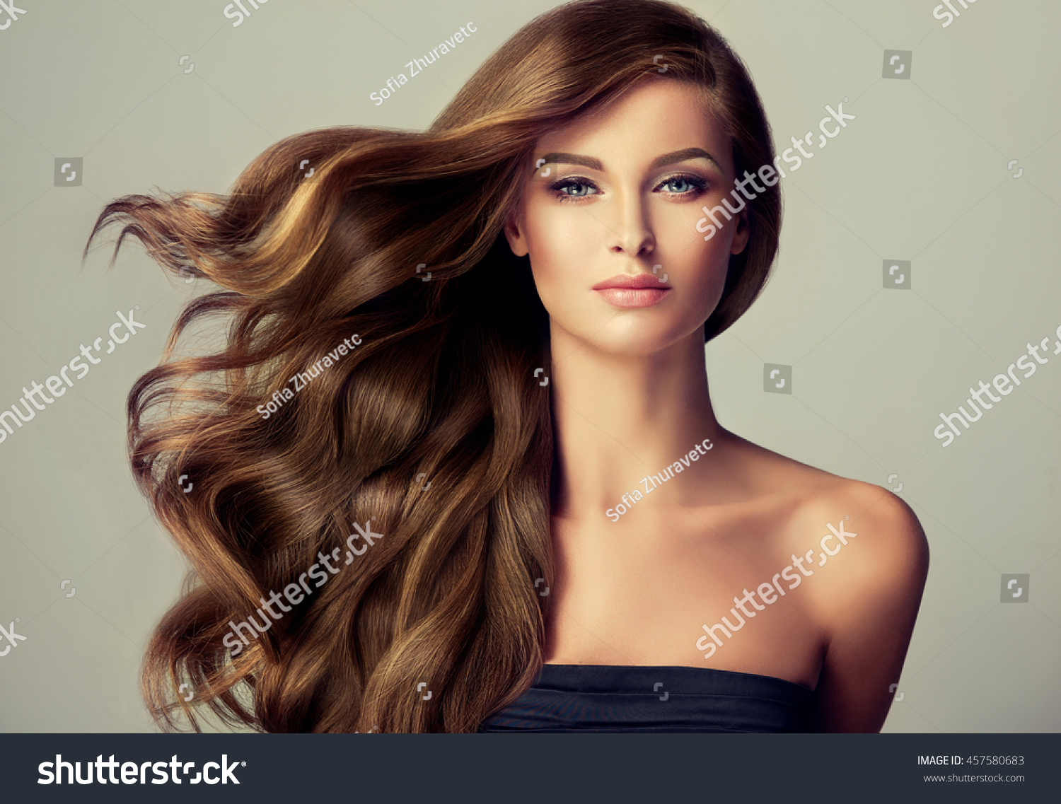 Brunette  girl with long  and   shiny wavy hair .  Beautiful  model with curly hairstyle . #457580683