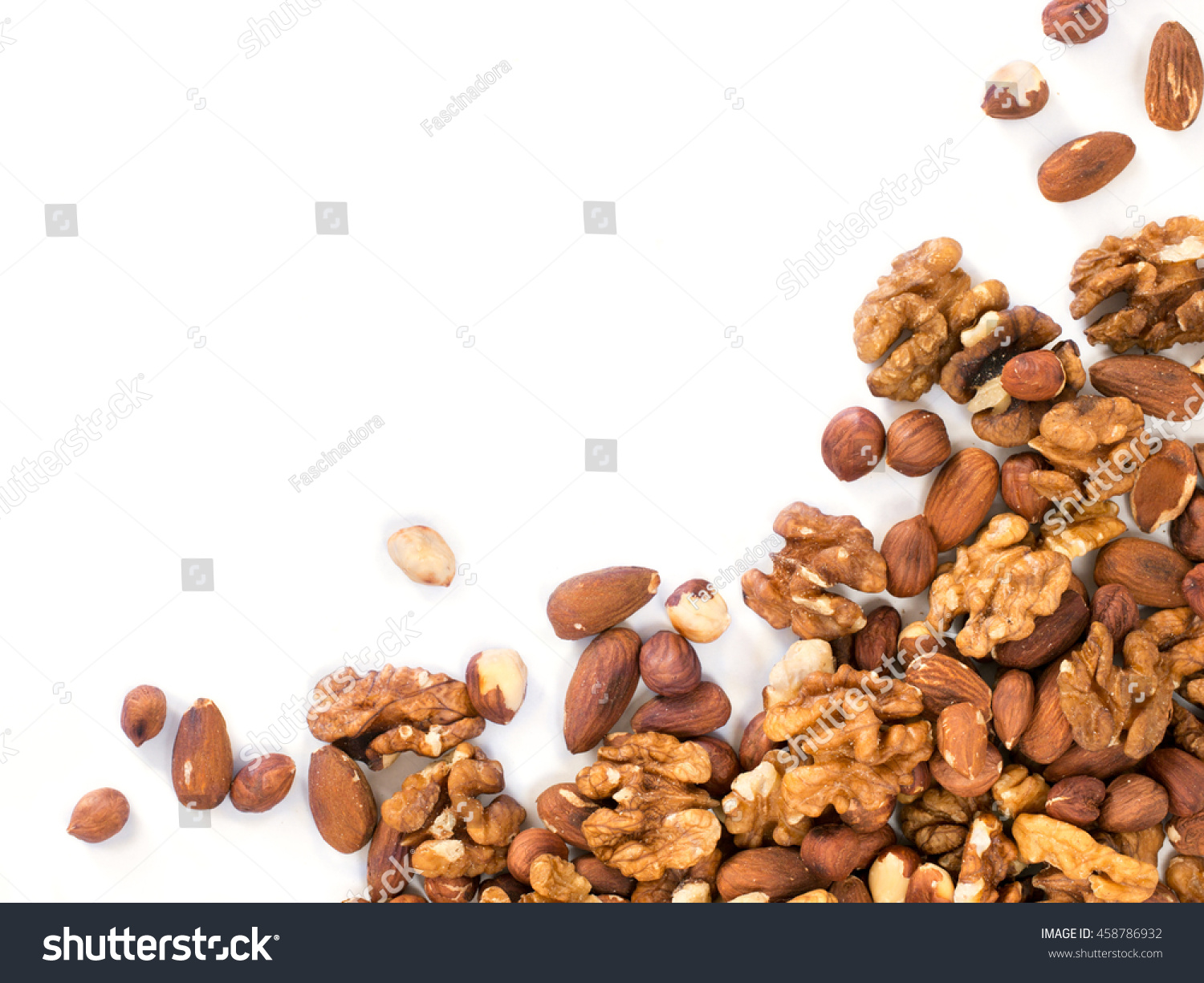 Background of mixed nuts - hazelnuts, walnuts, almonds - with copy space. Isolated one edge. Top view or flat lay #458786932