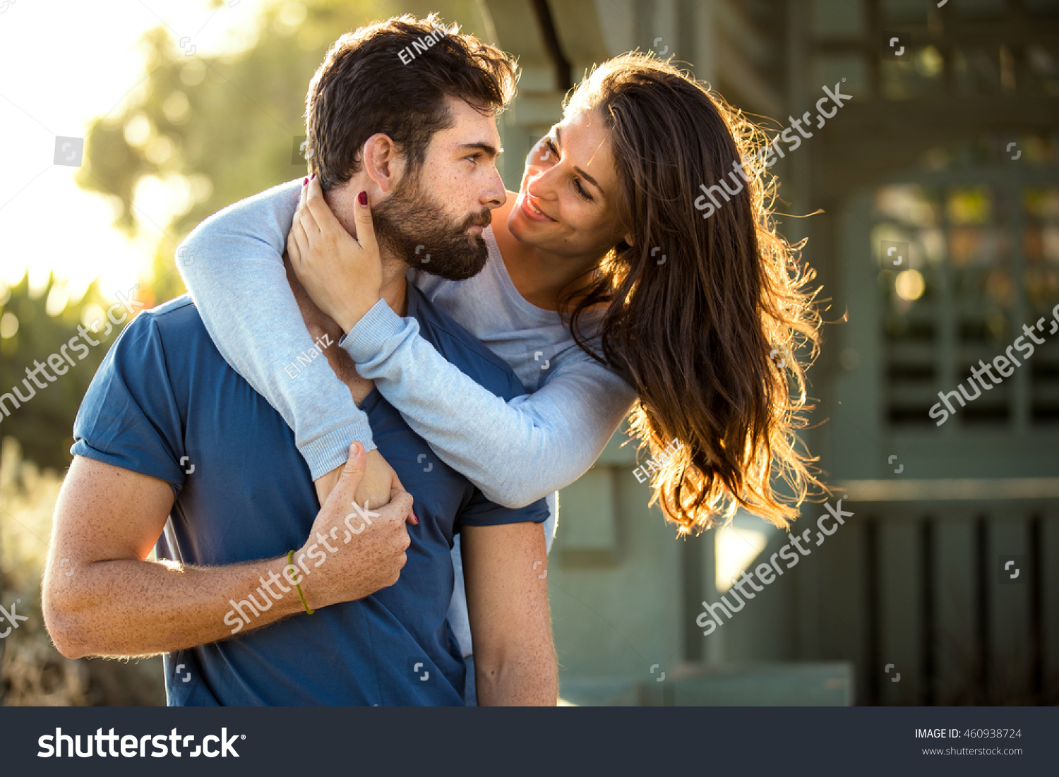 Two lovers in blue clothing in nature park outdoors hug and kiss #460938724