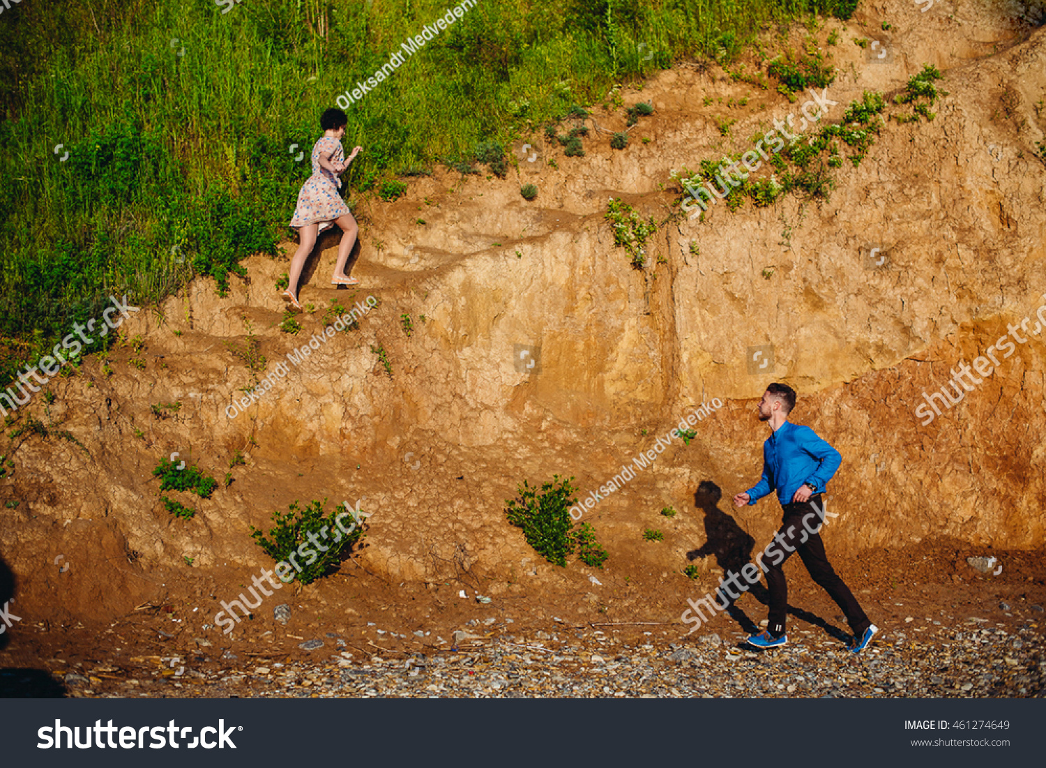 Man runs to the woman while she climbs the hill #461274649