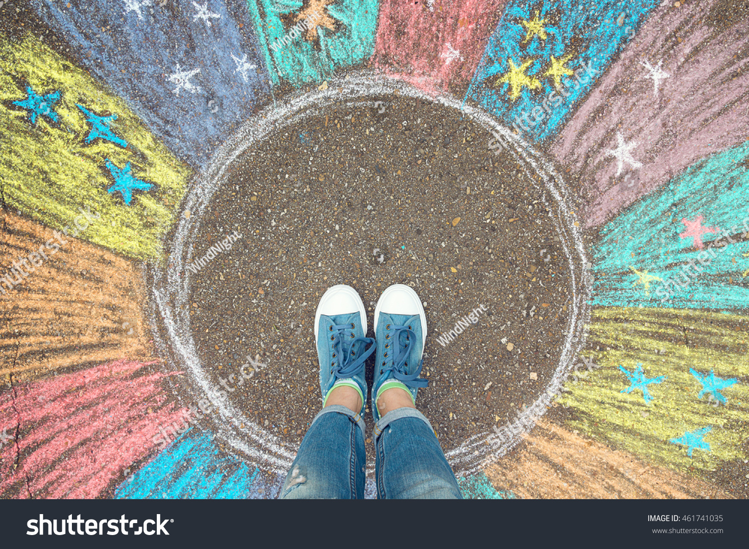 Comfort zone concept. Feet standing inside comfort zone circle surrounded by rainbow stripes painted with chalk on the asphalt. #461741035