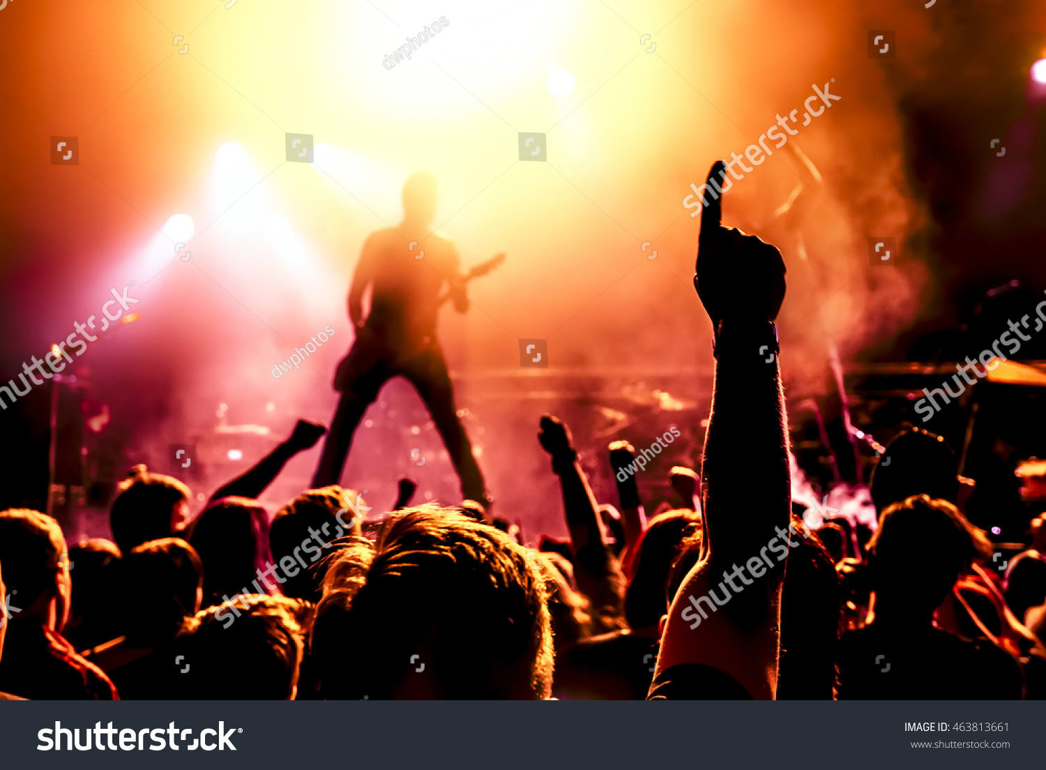 silhouette of guitar player in action on stage in front of concert crowd #463813661