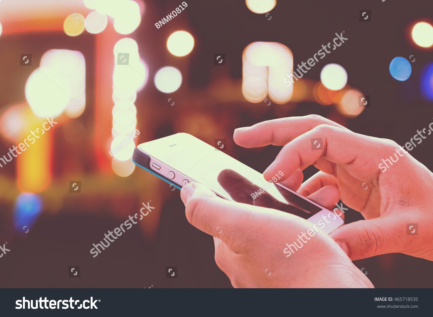 Close up of girl hands hoding modern smart phone , woman's hand using cellphone at night city, bokeh light #465718535
