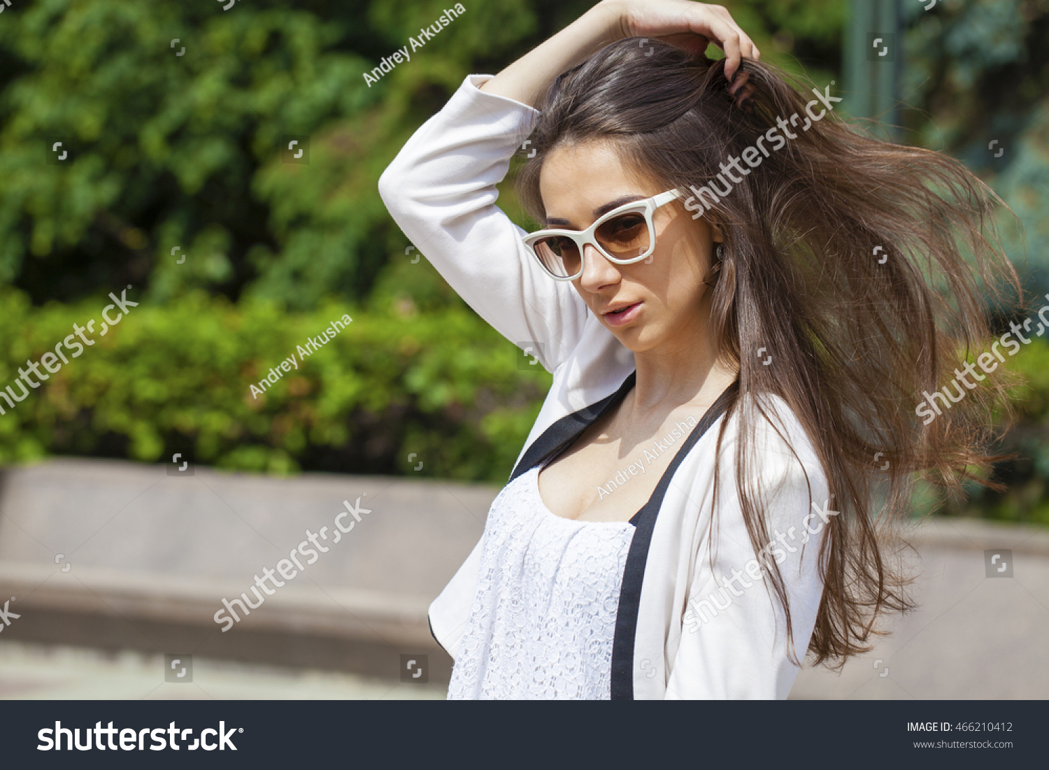 Portrait close up of young beautiful brunette woman in white fashion sunglasses, summer street outdoors #466210412
