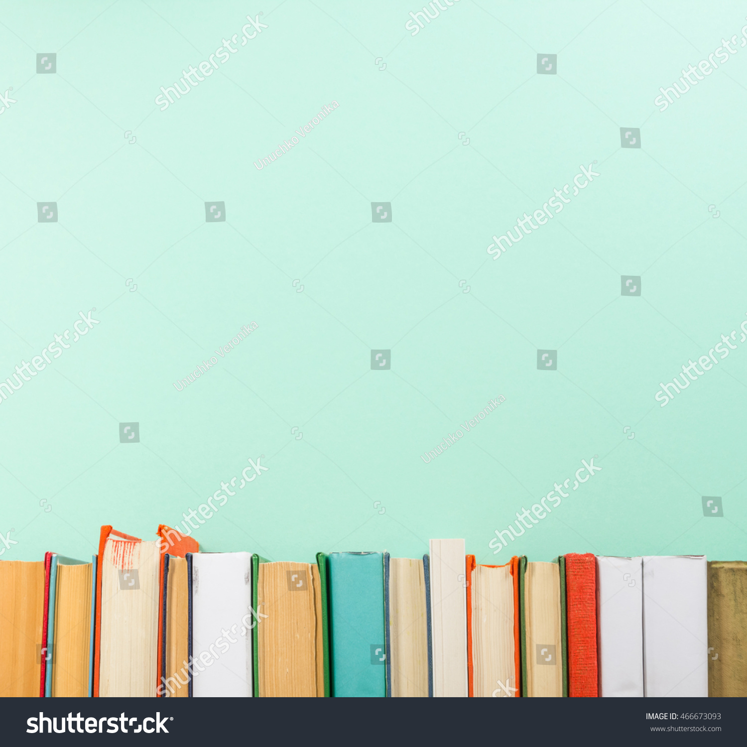 Books on grunge wooden table desk shelf in library. Back to school background with copy space for your ad text. Old hardback   no labels, blank spine #466673093