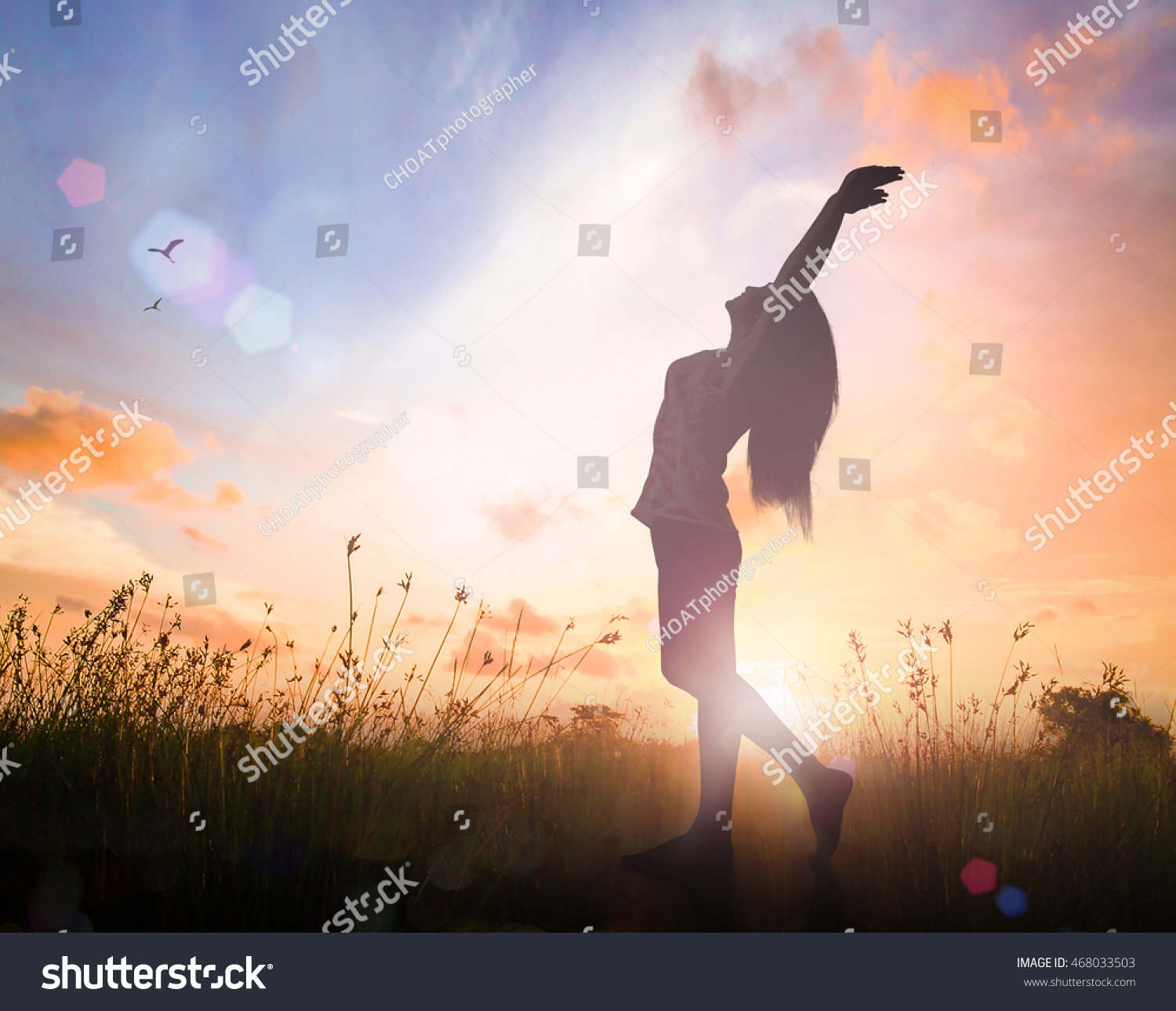 World mental health day concept: Silhouette of healthy woman raised hands for praise and worship God at autumn sunset meadow background #468033503
