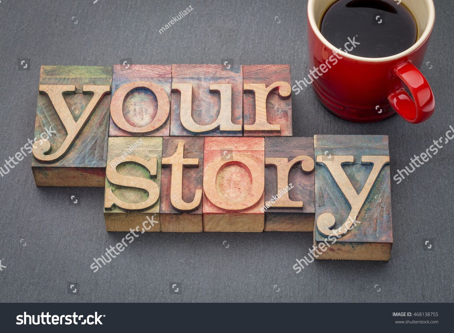 your story - word abstract in  letterpress wood type stained by color inks against a slate stone with a cup of coffee #468138755