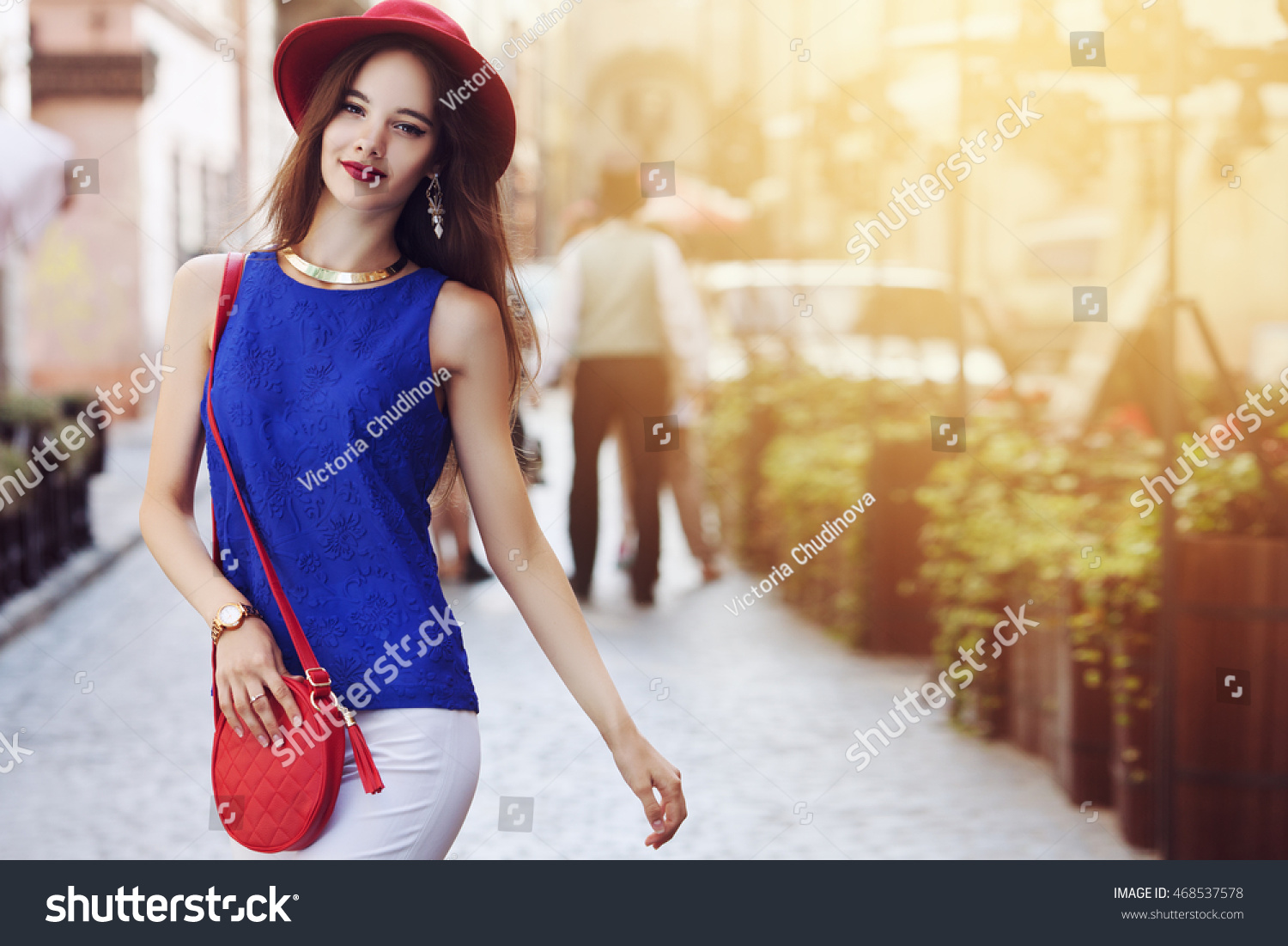 Outdoor portrait of young beautiful happy smiling woman posing on street. Model wearing stylish hat and clothes. Girl looking at camera. Female fashion. Sunny day. City lifestyle. Copy space for text #468537578