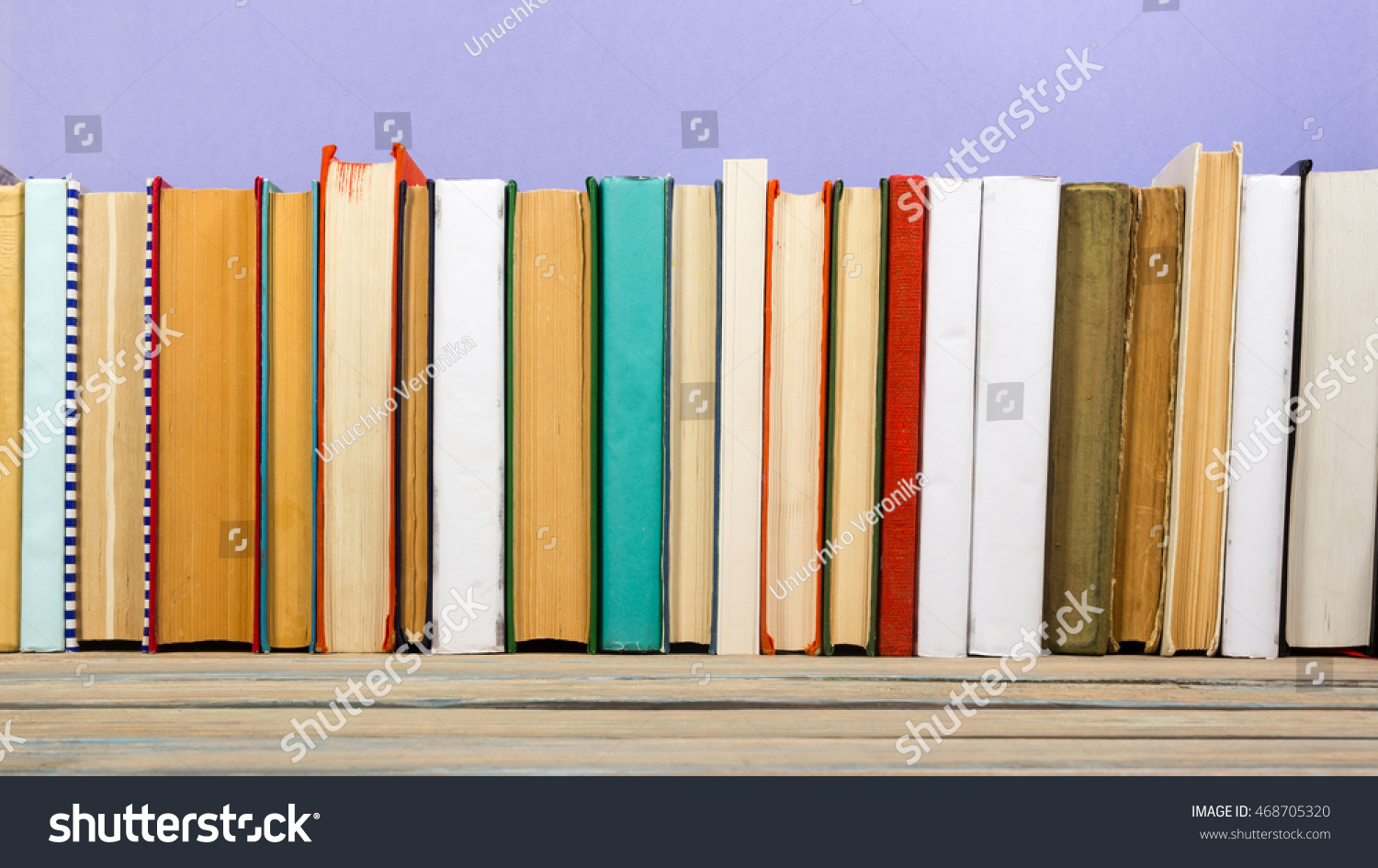 Books on grunge wooden table desk shelf in library. Back to school background with copy space for your ad text. Old hardback   no labels, blank spine #468705320