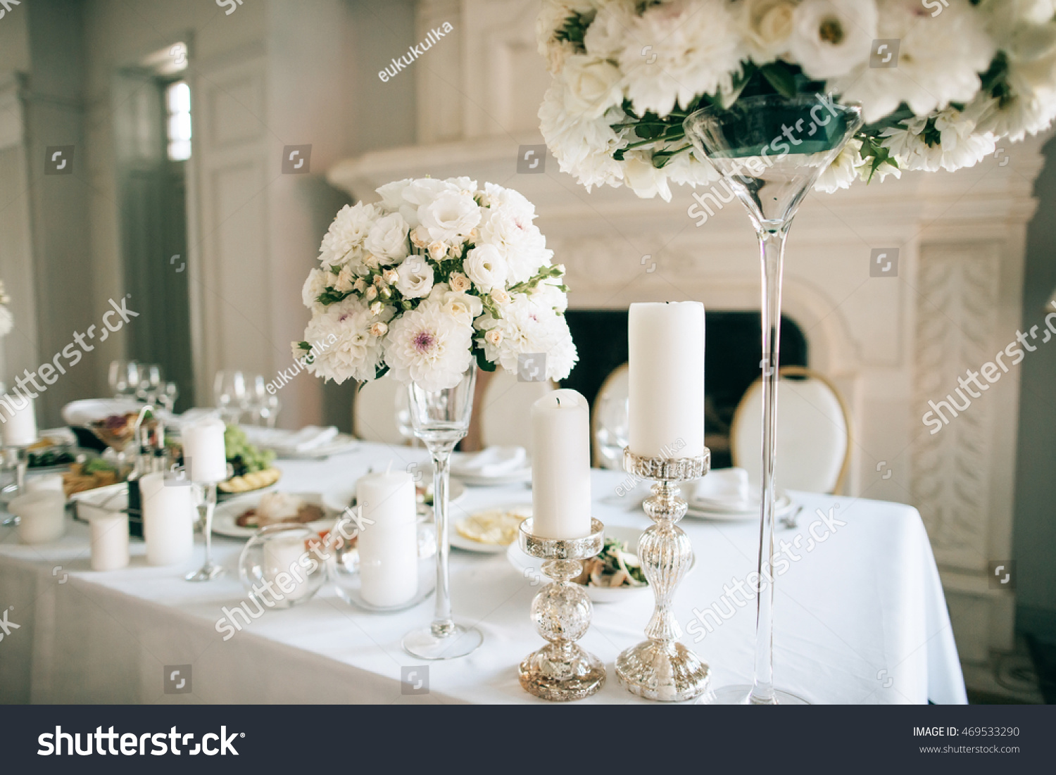 Table decor with white flowers  and candles for an event party or wedding reception #469533290