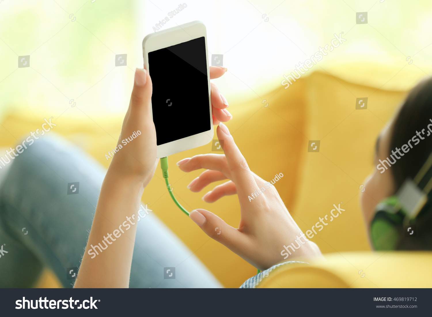Woman listening to music on smartphone in the room #469819712